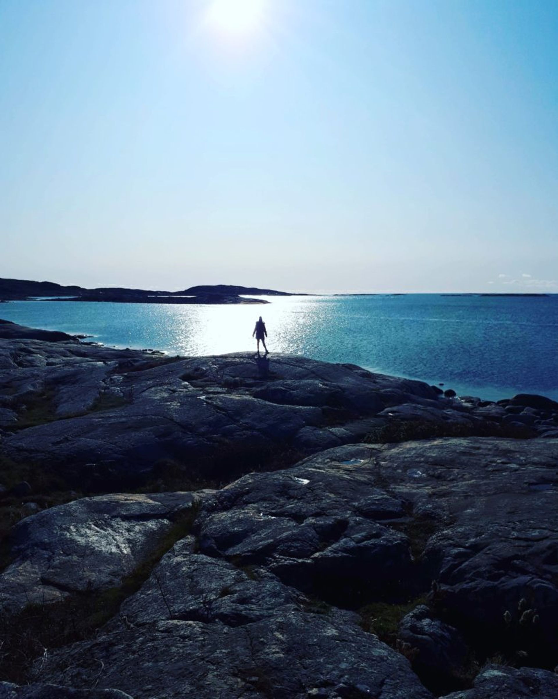 Person standing beside the sea.