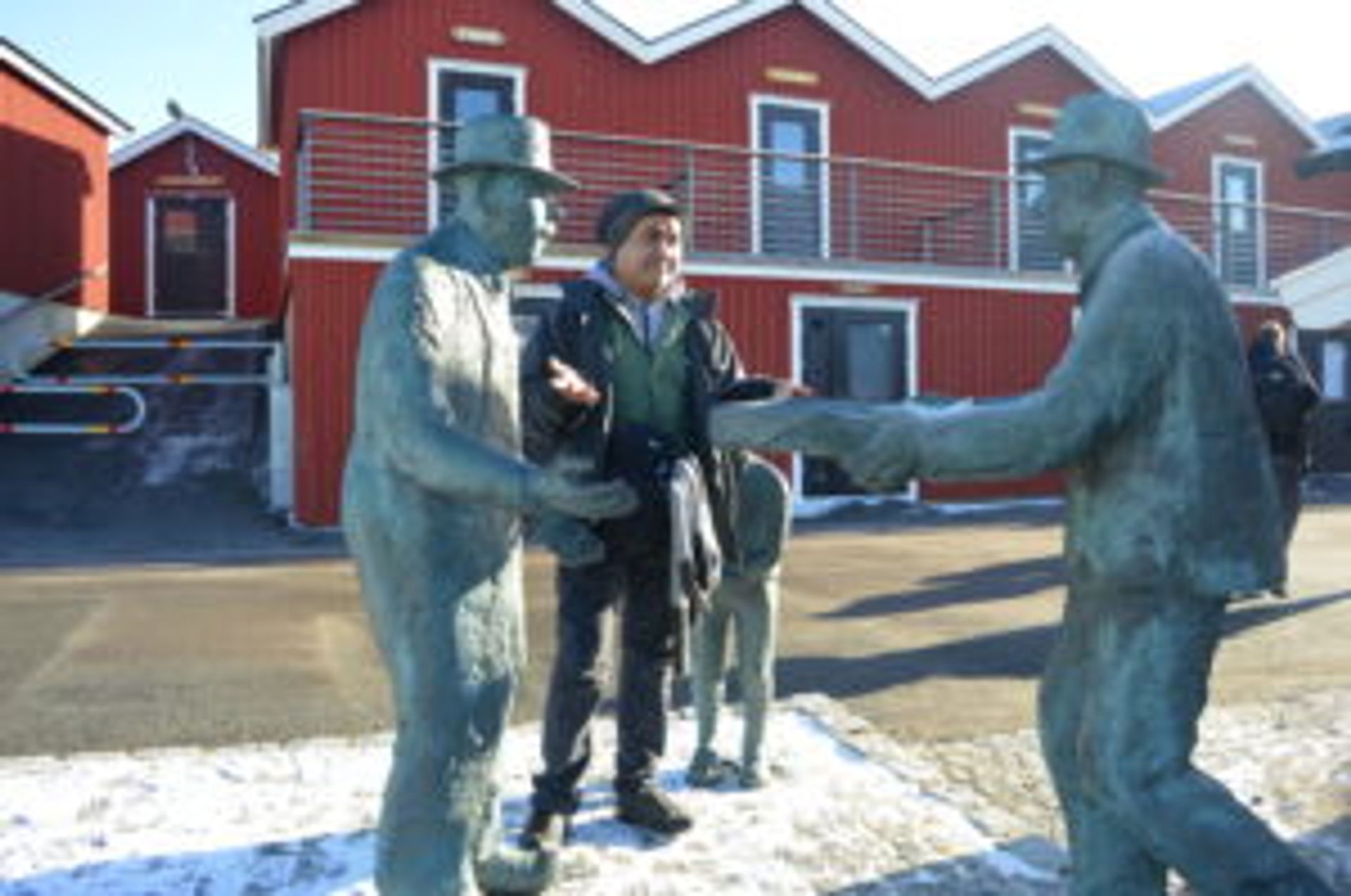 Student standing beside statues.