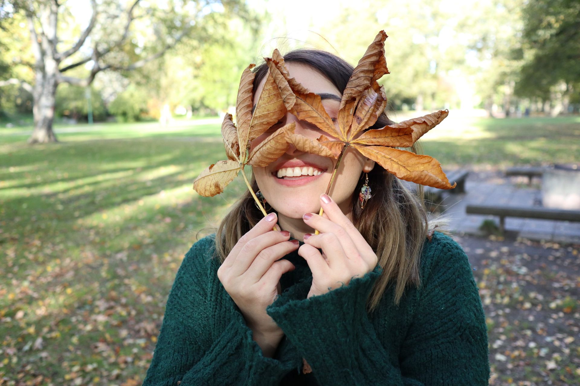 Student holds up orange leaves.