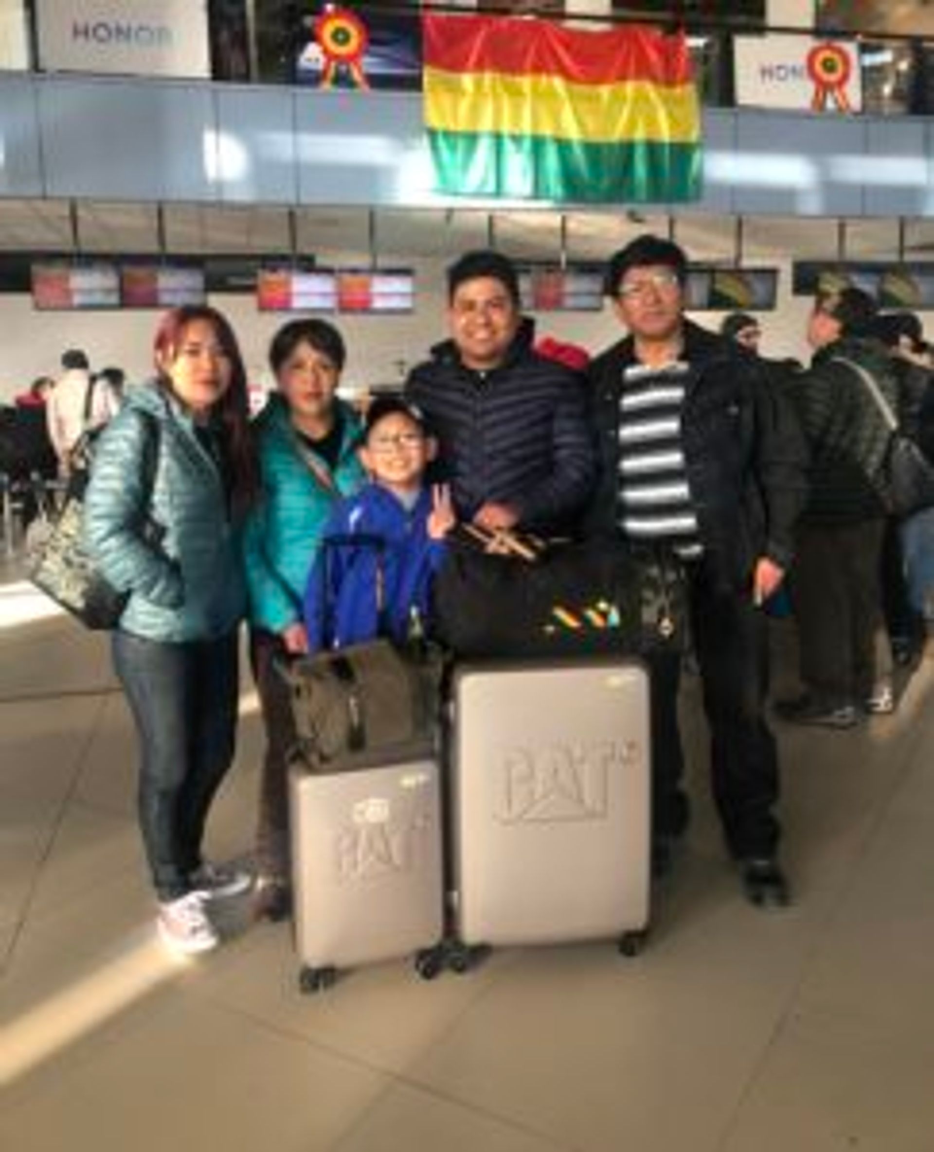 A family poses for a photo at an airport.