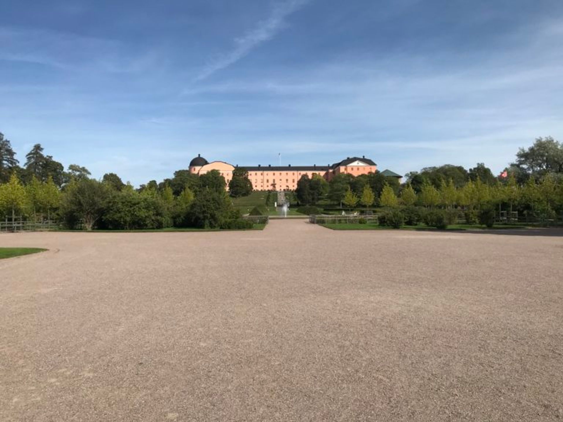 Botantical gardens in front of a large, pink castle.