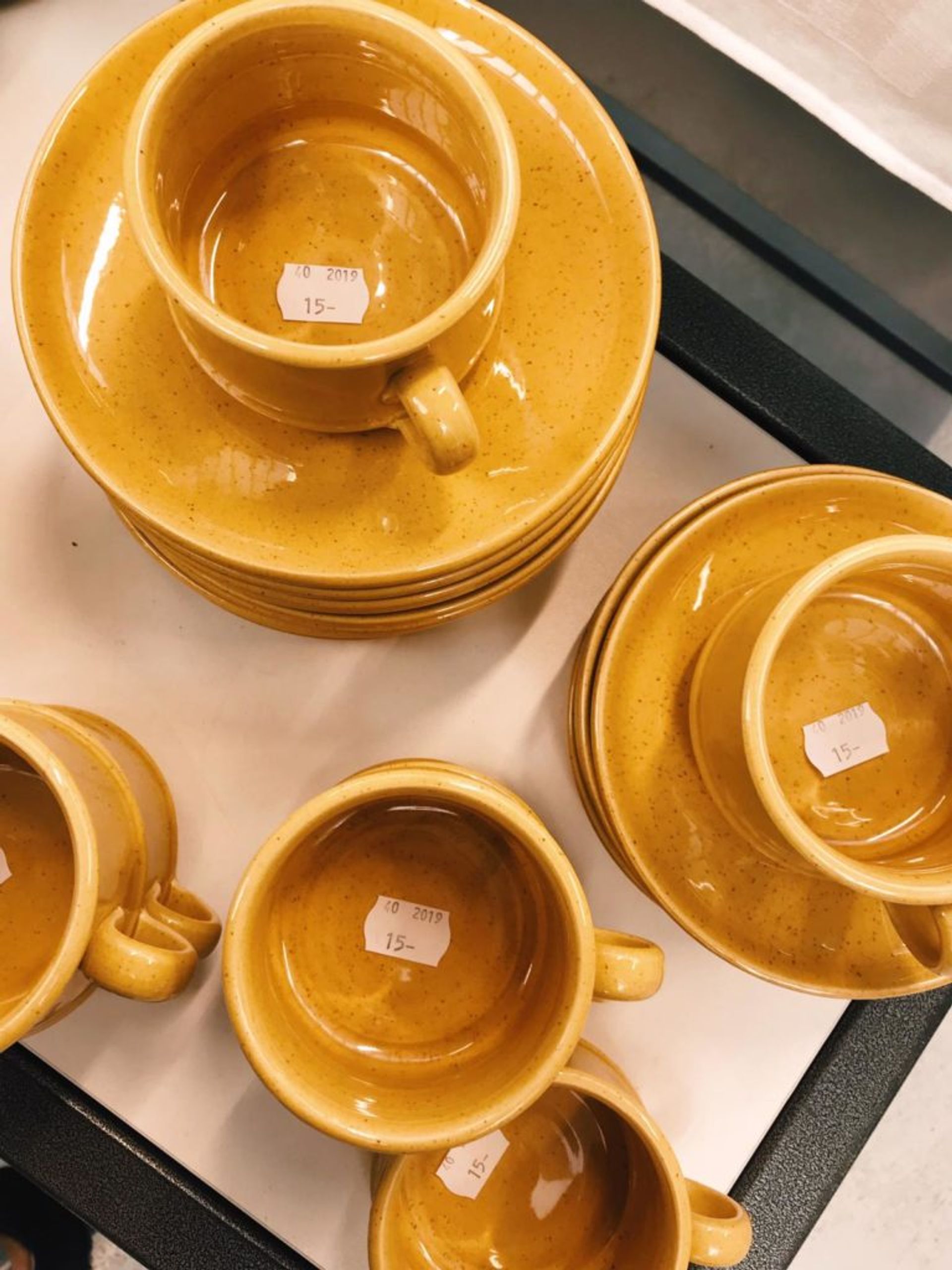 Close-up of mustard yellow cups and saucers.