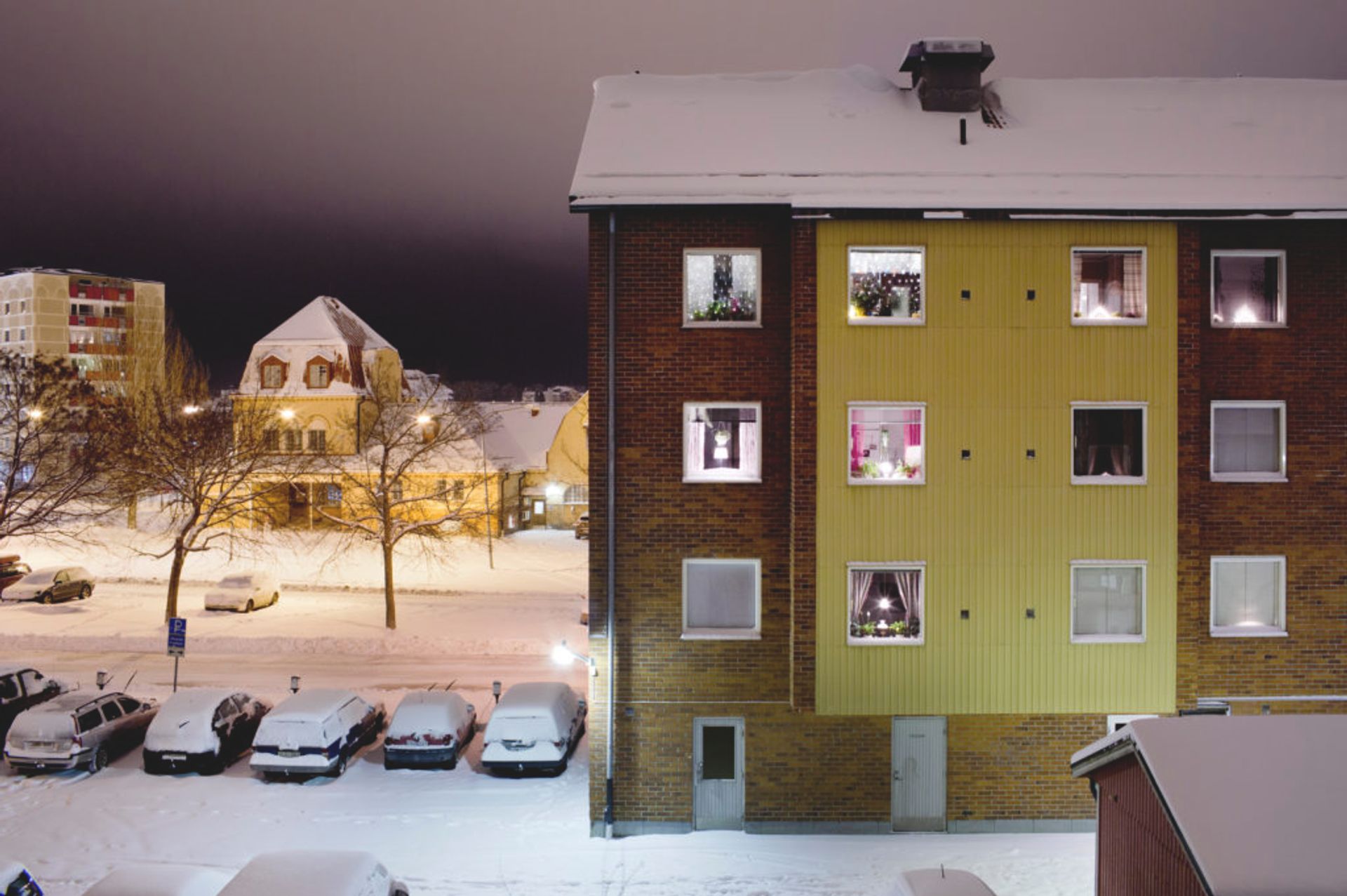 Apartment building covered in snow.