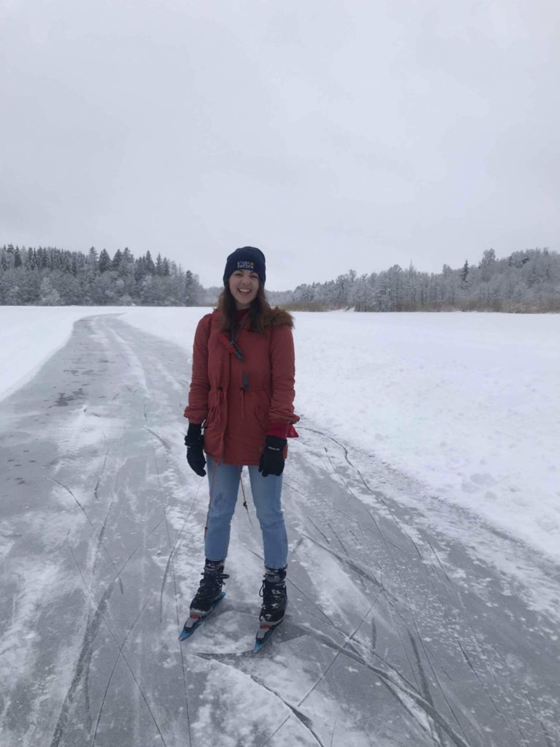 Woman standing with ice skates on on frozen lake 