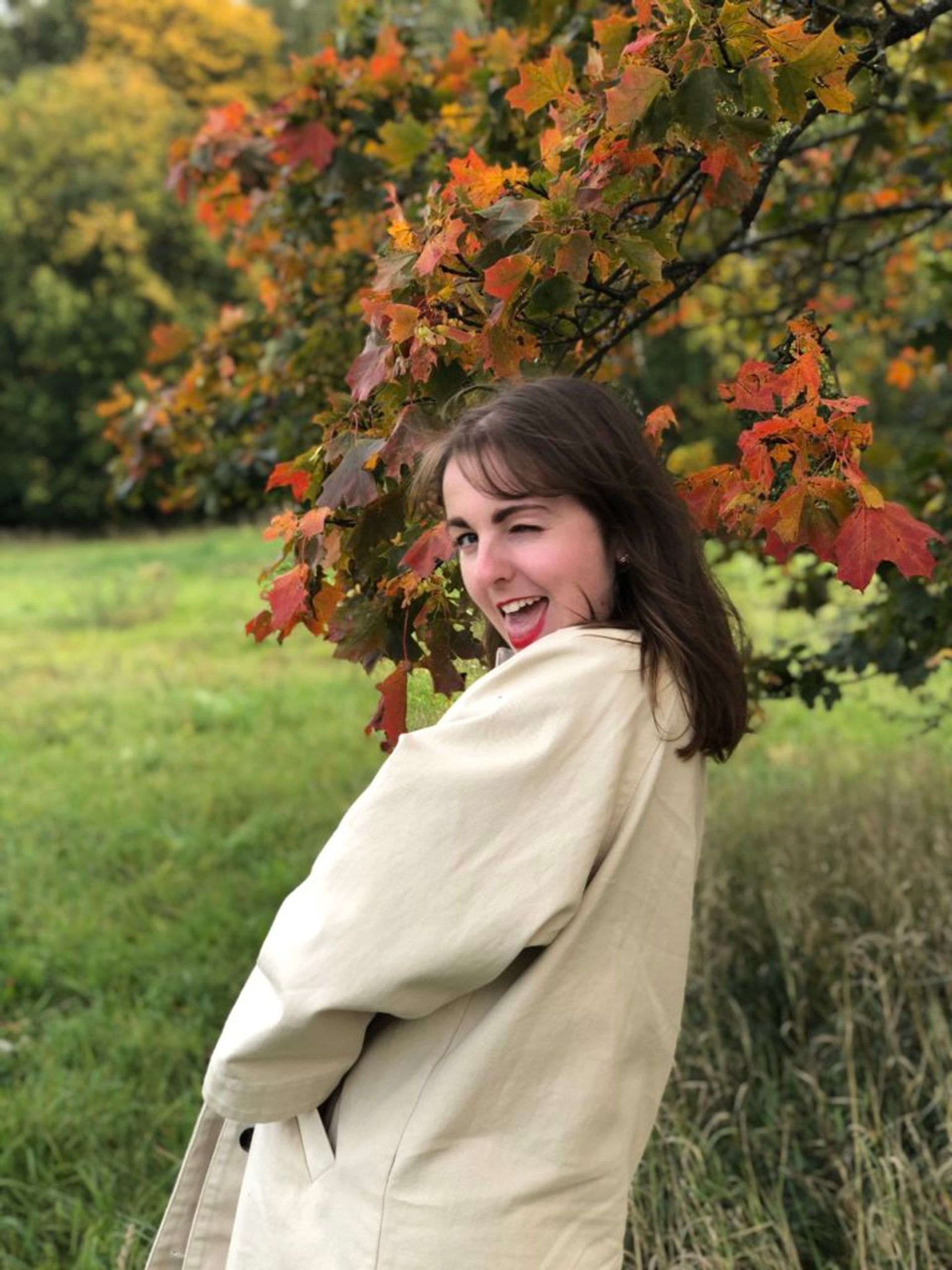 Student standing in front of a tree.