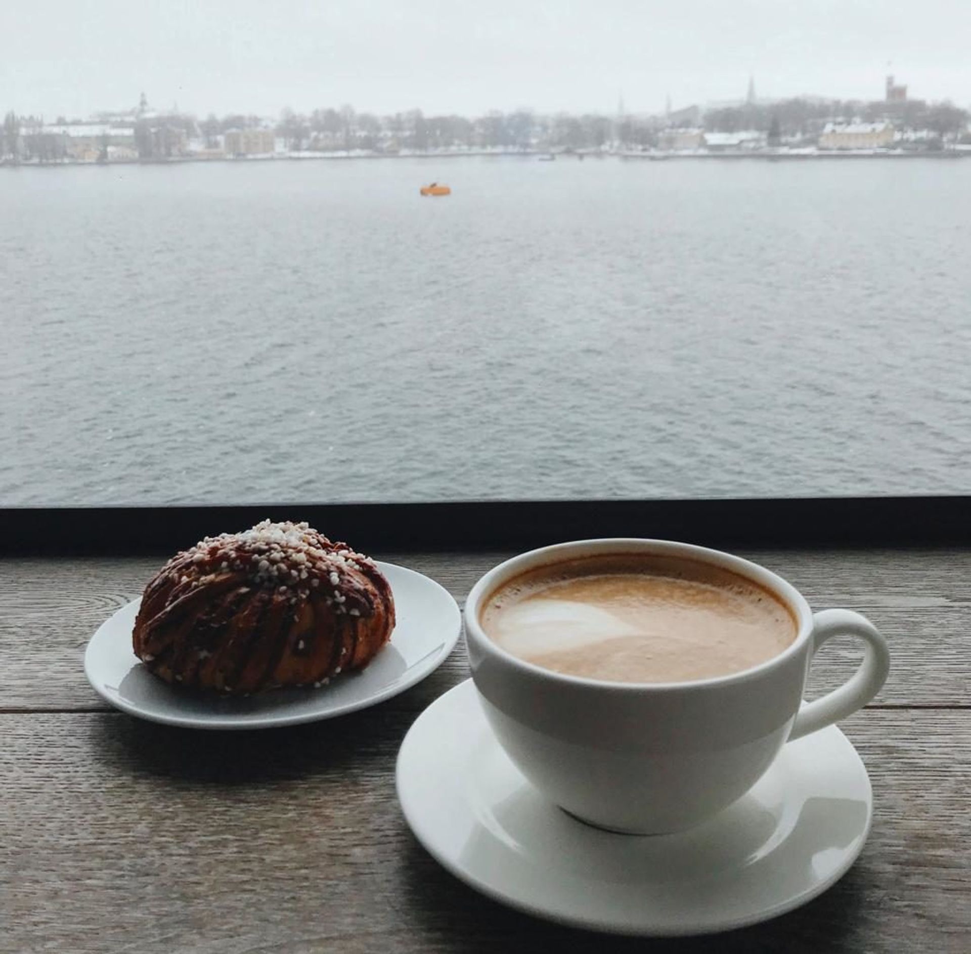 A cinnamon bun and cup of coffee.