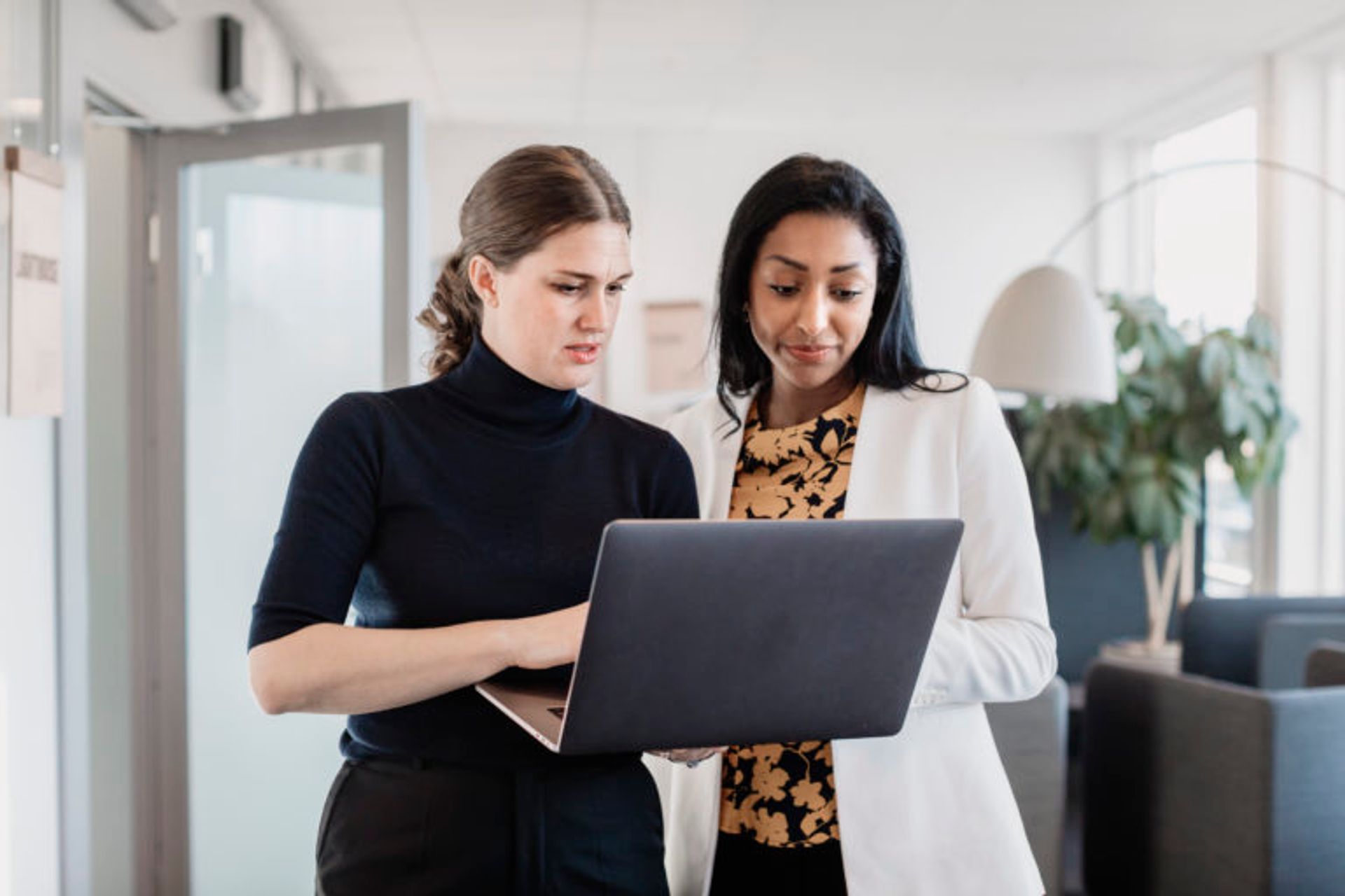 Two people looking at a laptop.