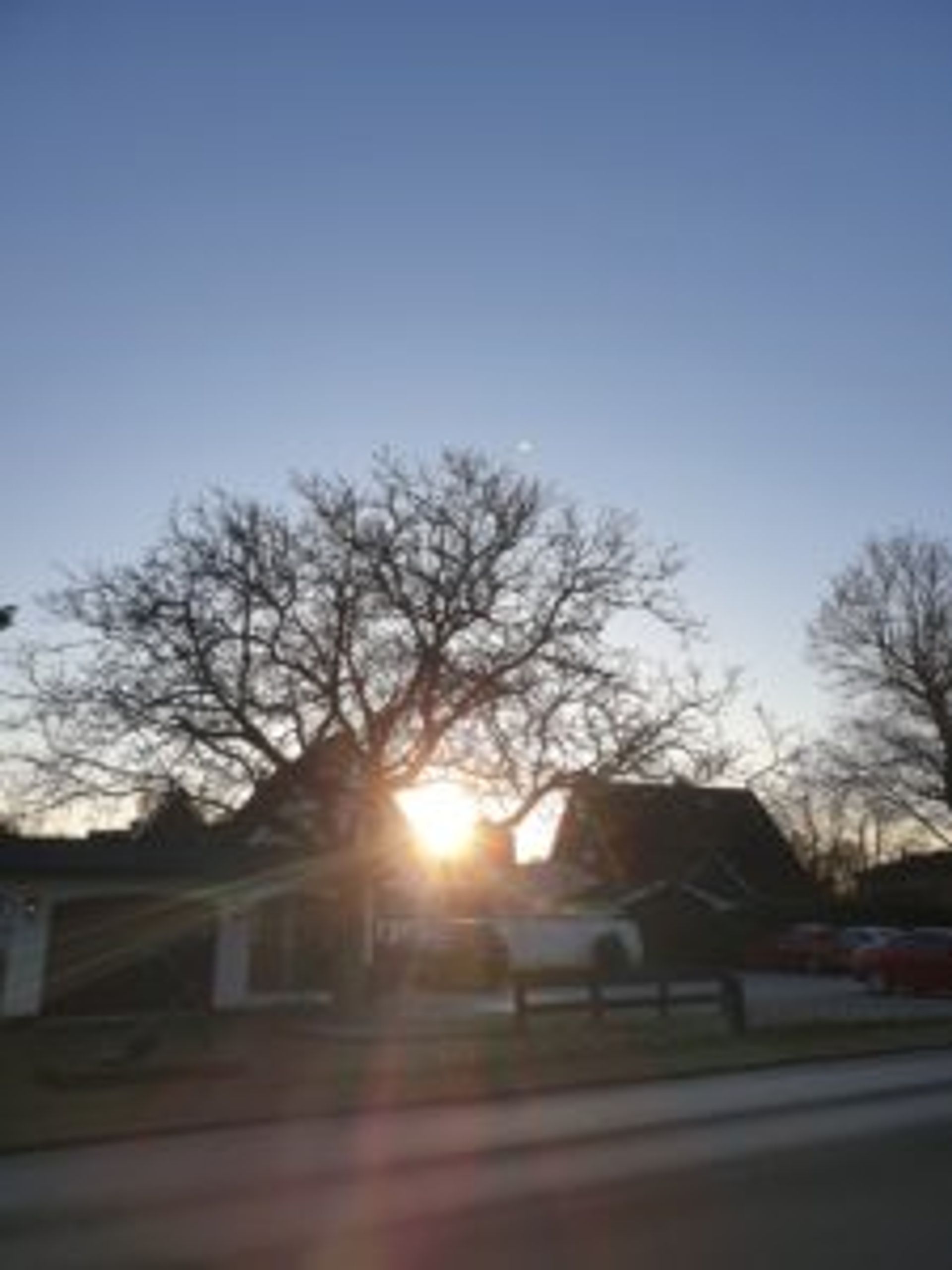 A sunset peeking through buildings.