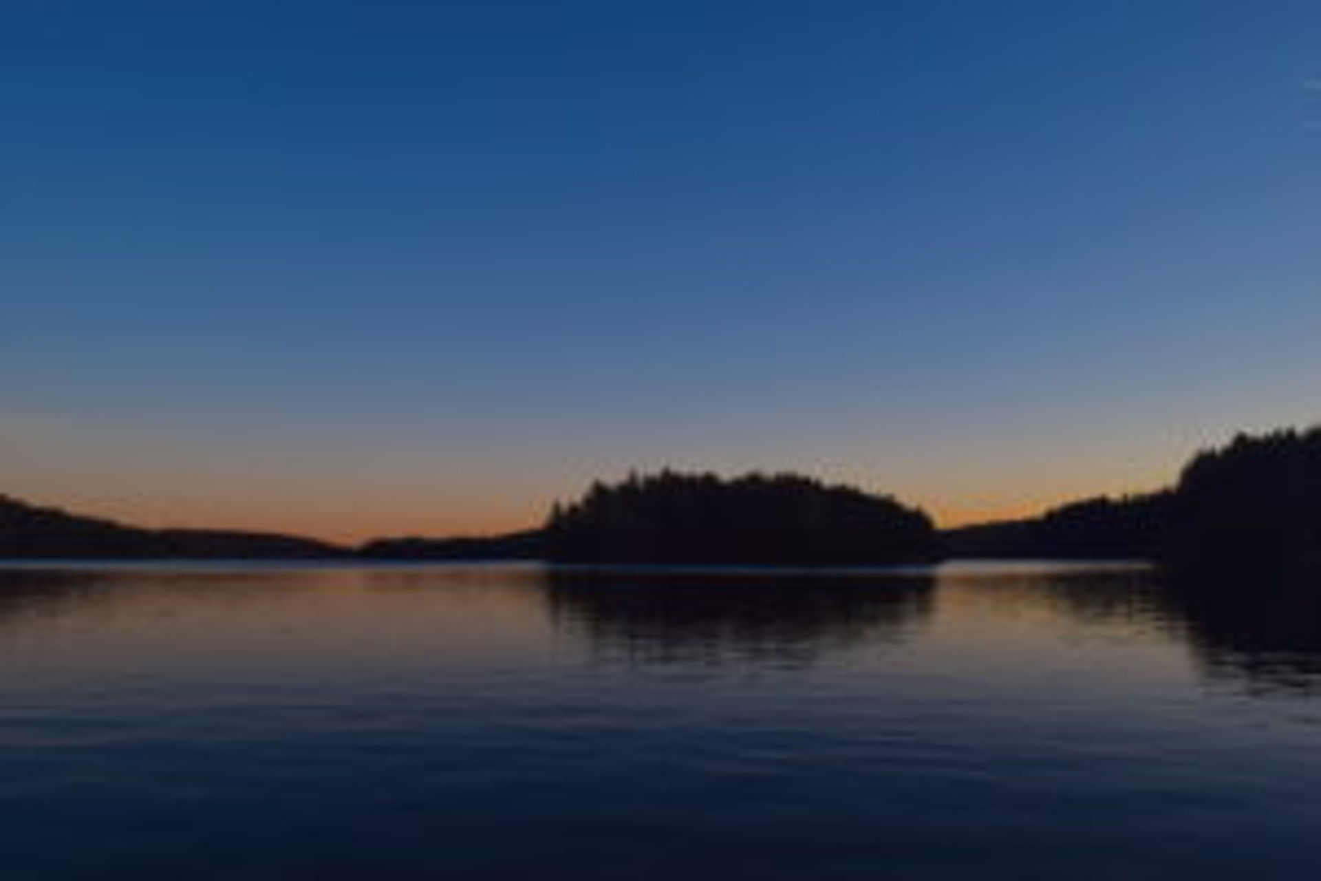 A blue and orange sunset over a lake.