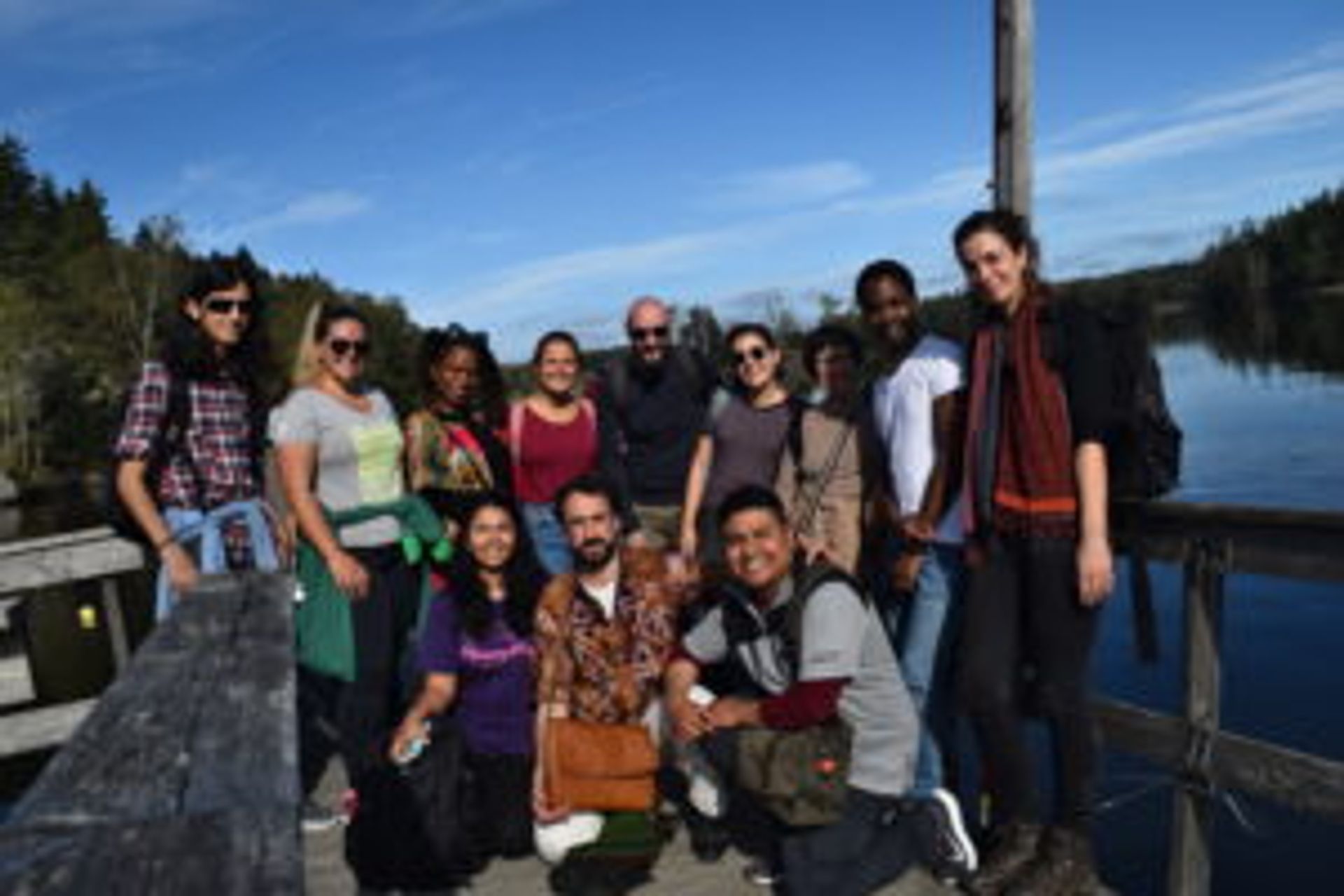 Camilo stands with the rest of his university class in front of a lake.