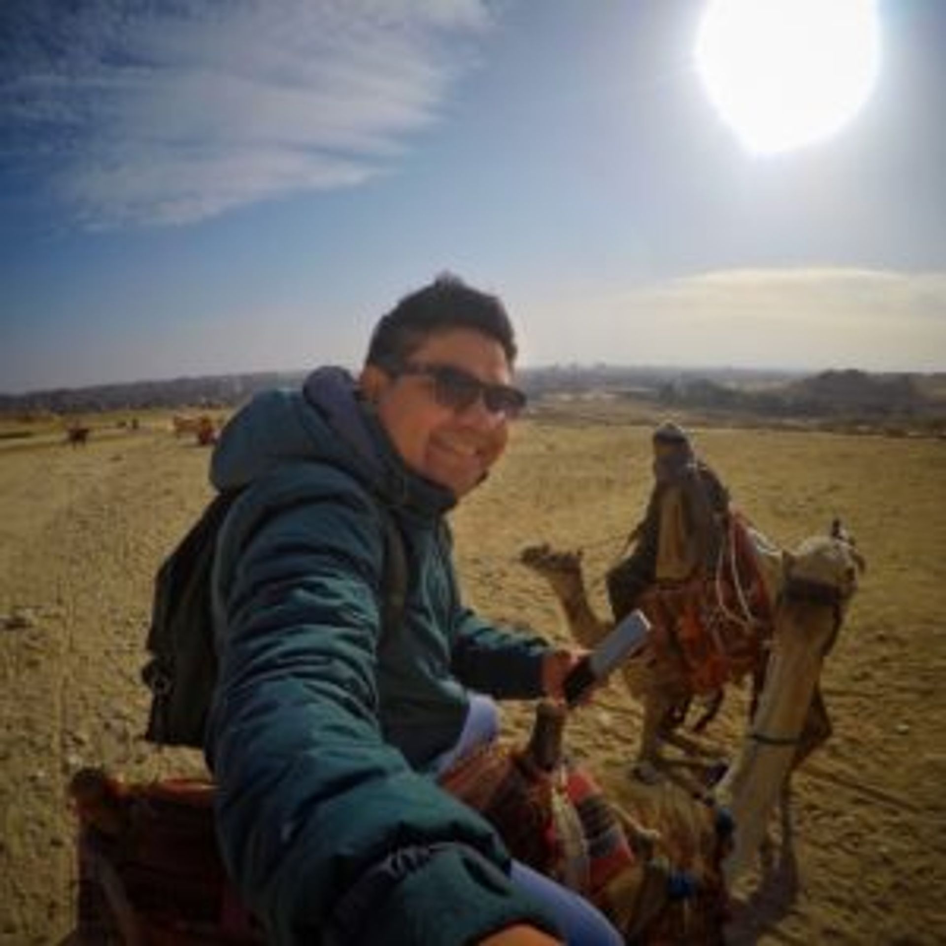 Camilo taking a selfie of himself sitting on a camel.