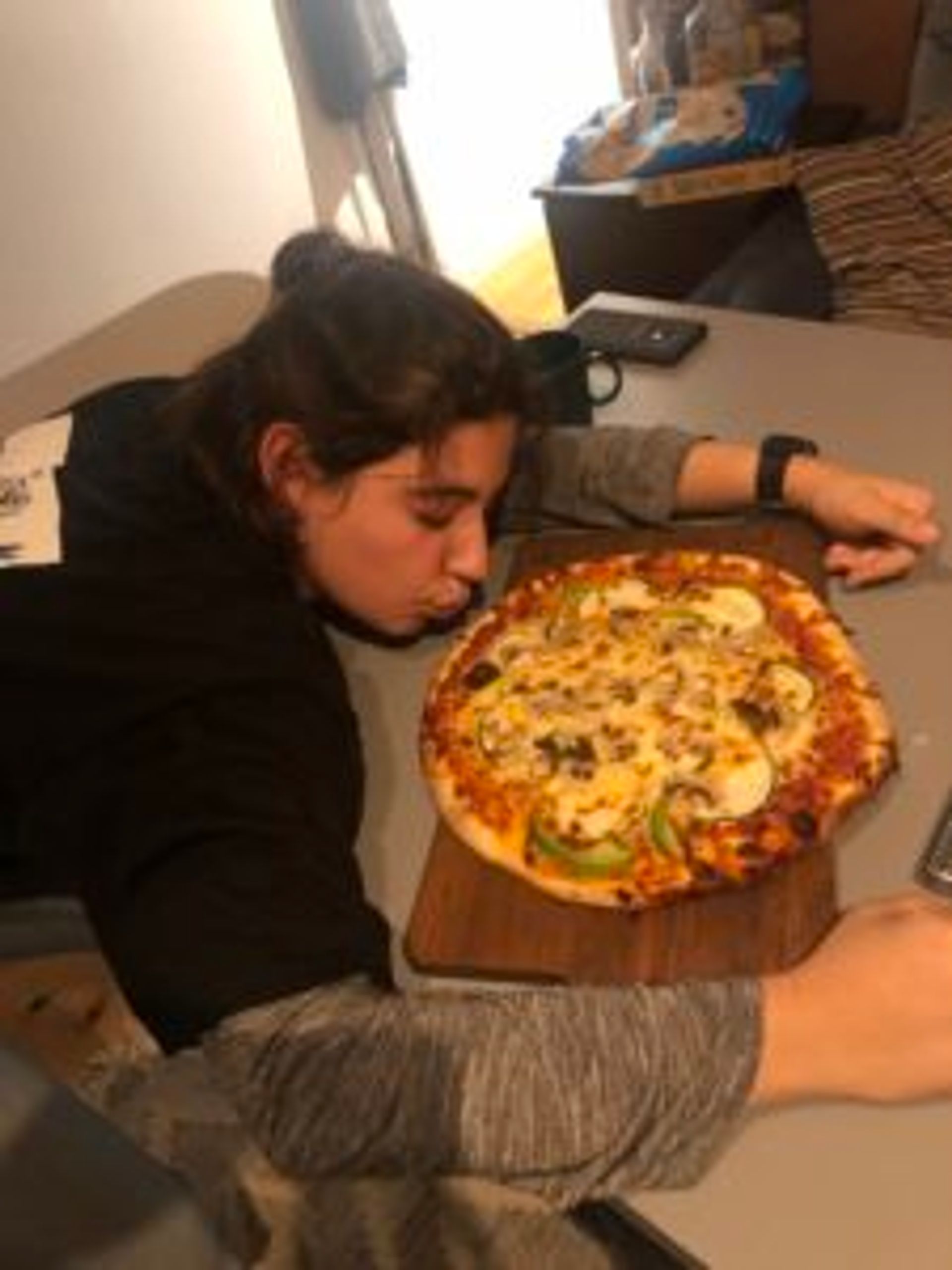 A person looking at a pizza.