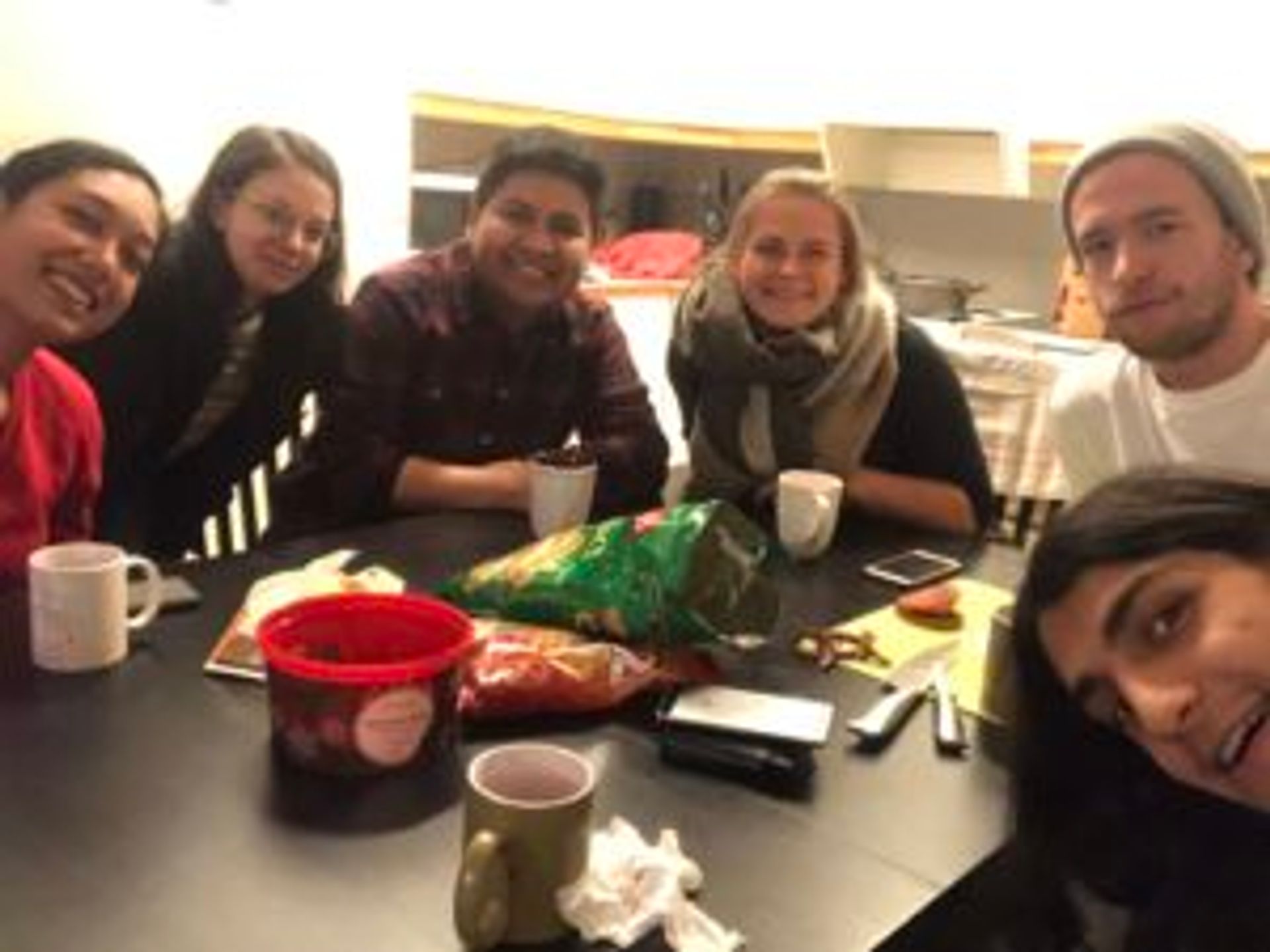 Camilo stis with friends eating dinner.