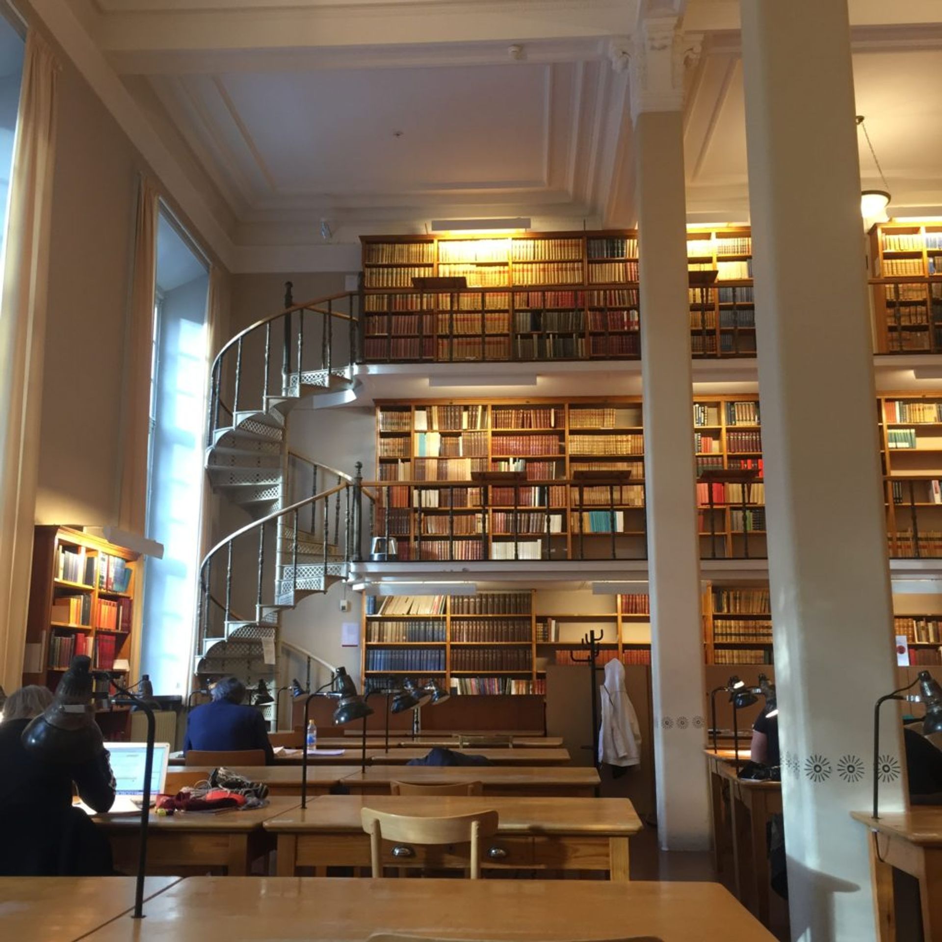 People sitting at desks working in a university library.