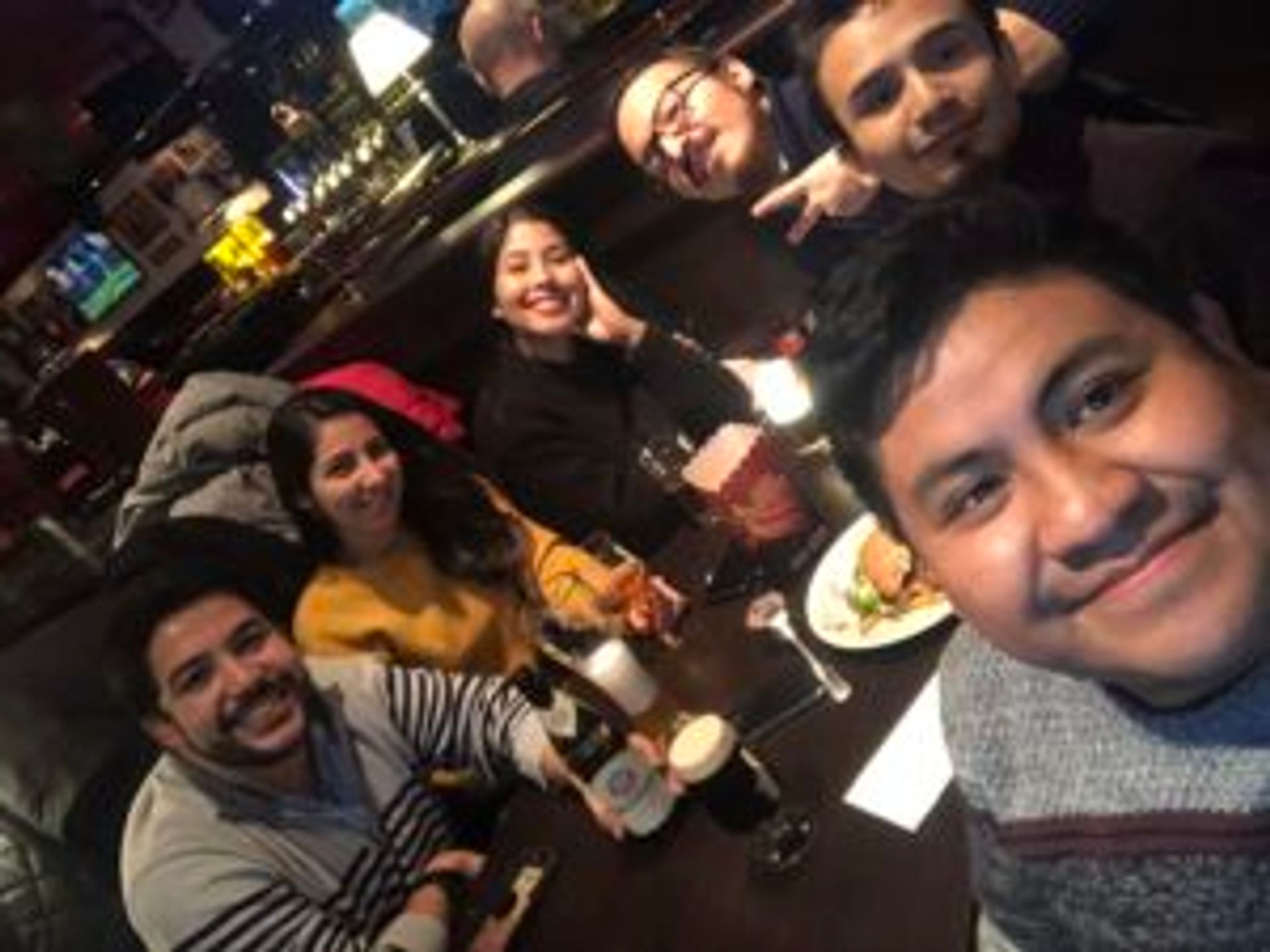 Camilo sits with several friends from South America in a bar.