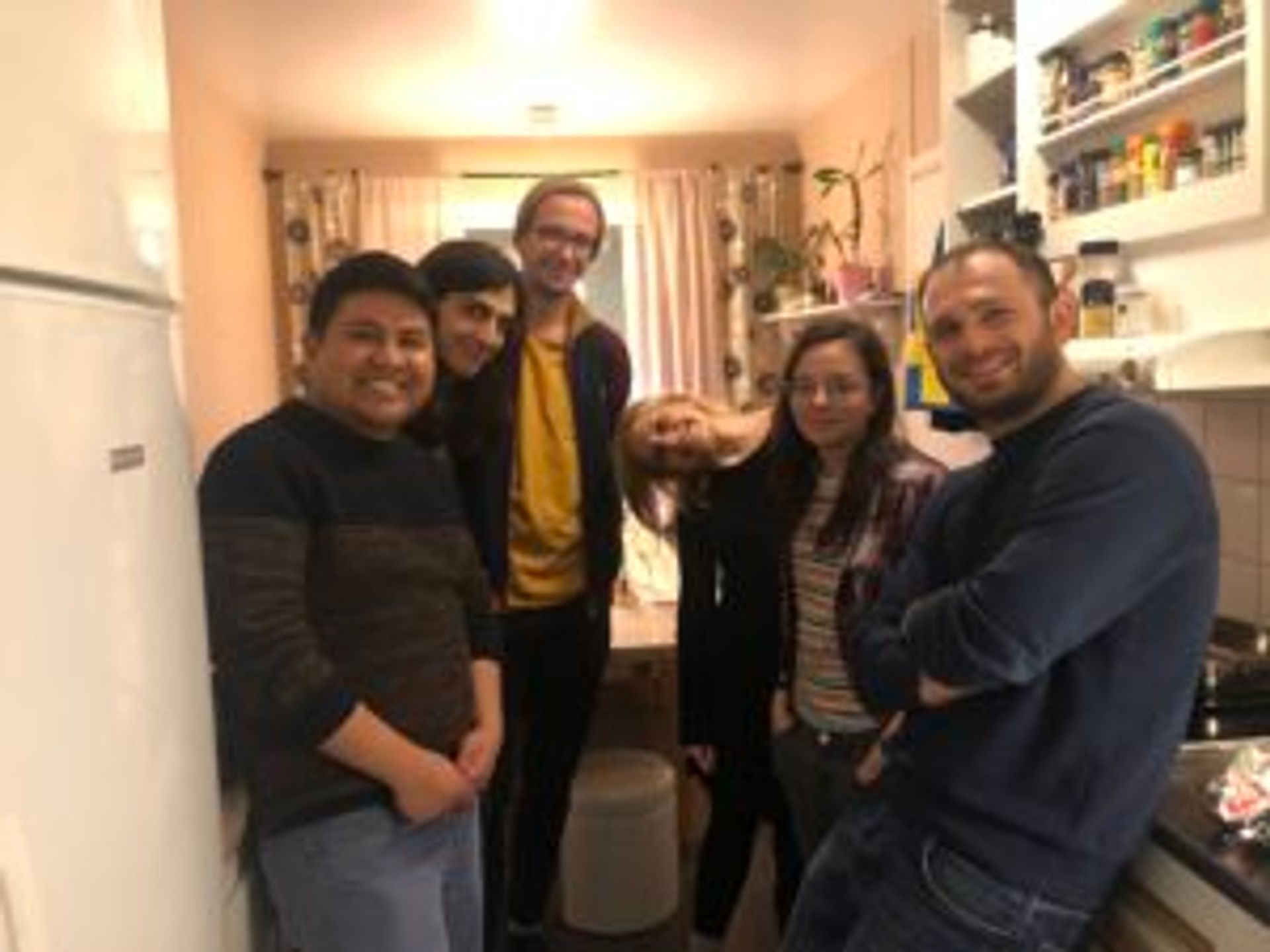 Camilo stands in a kitchen with friends.