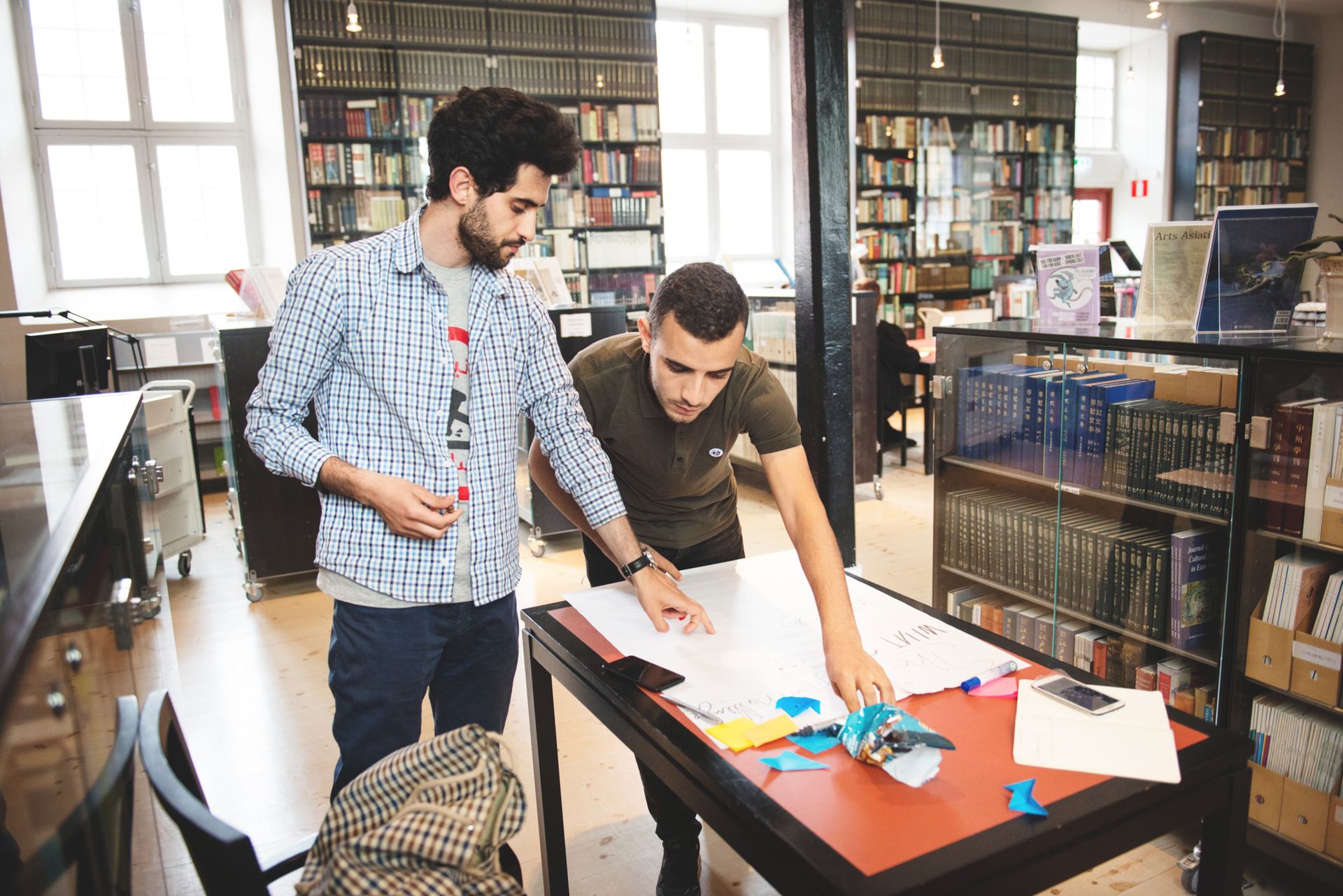 Two people working together in a llibrary