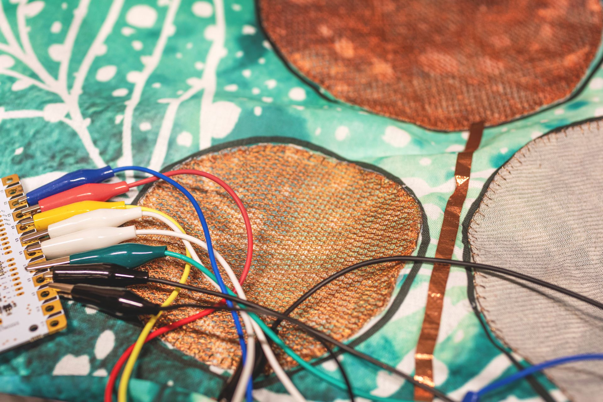 Copper wires weaved into blue textiles.