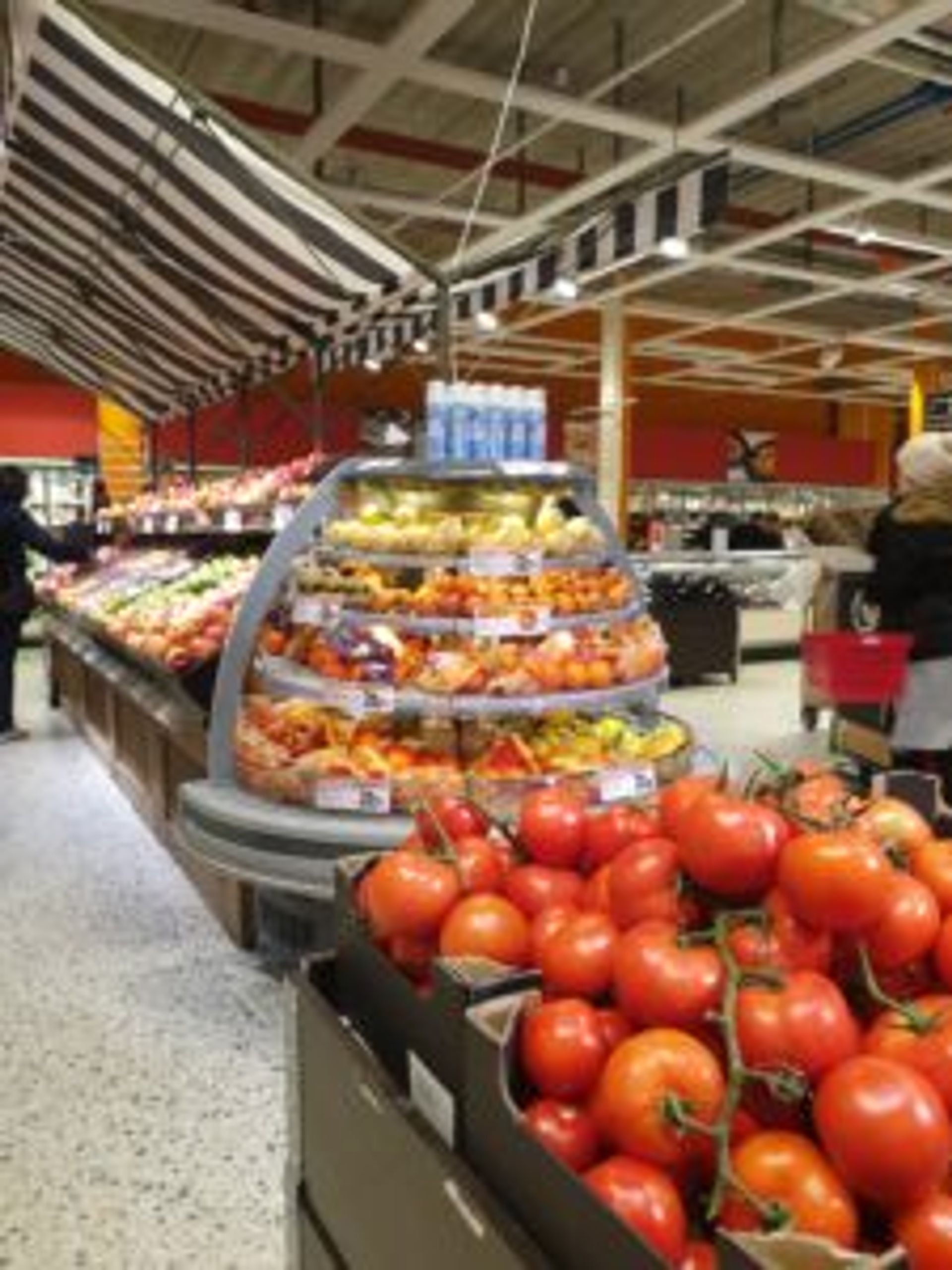 Aisles of fresh fruit and vegetables in a supermarket.