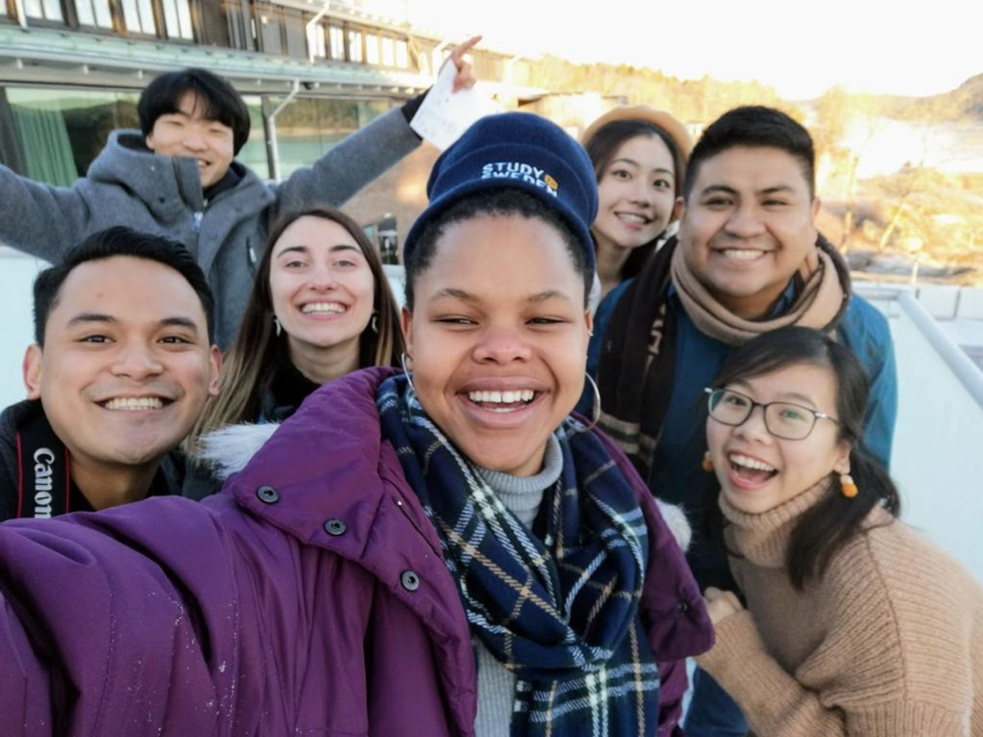 Lusanda taking a group selfie, surrounded by six Study in Sweden digital ambassadors.