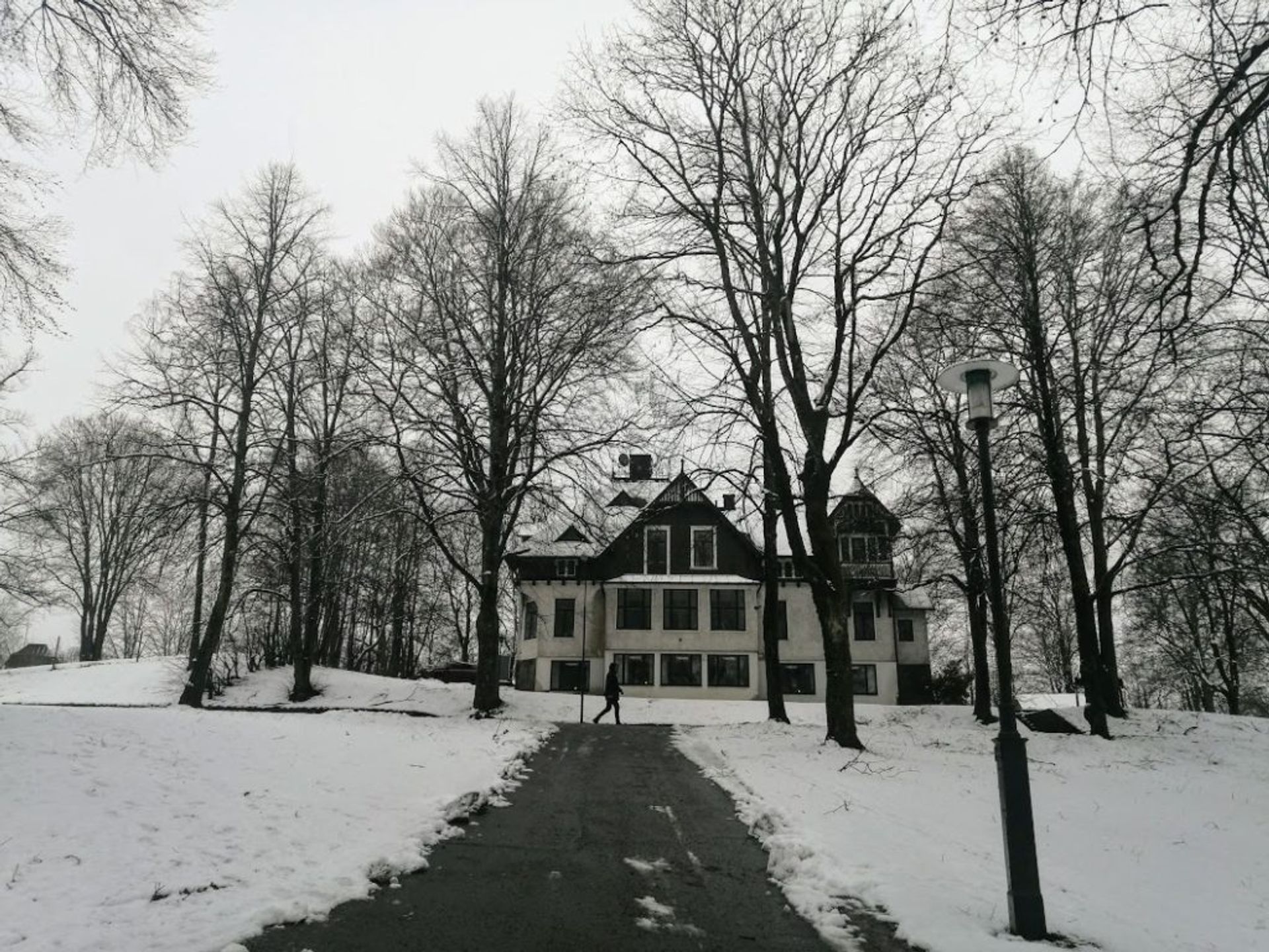 A large, white house surrounded by snow.