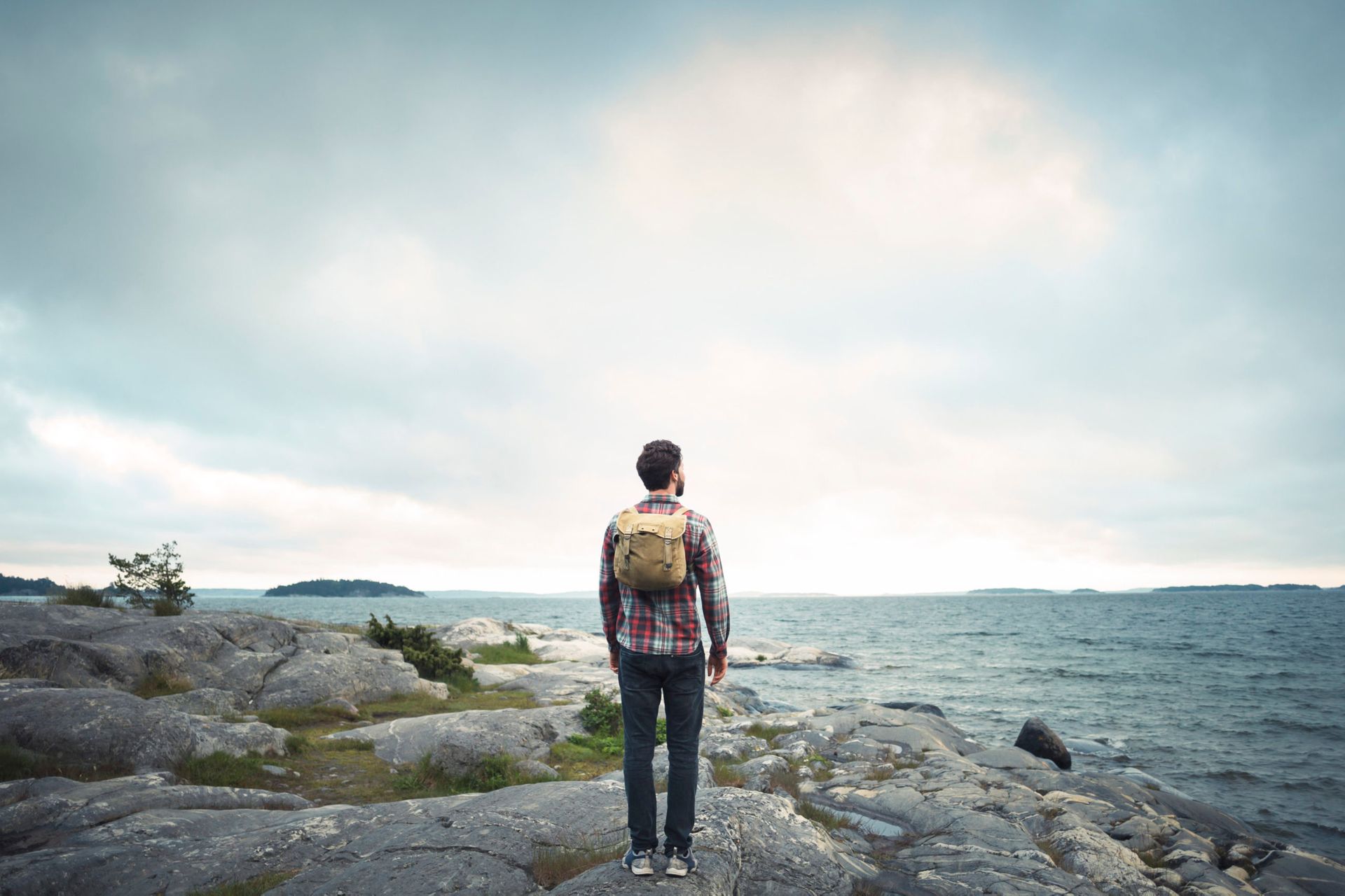 Man standing on rocks by the sea.