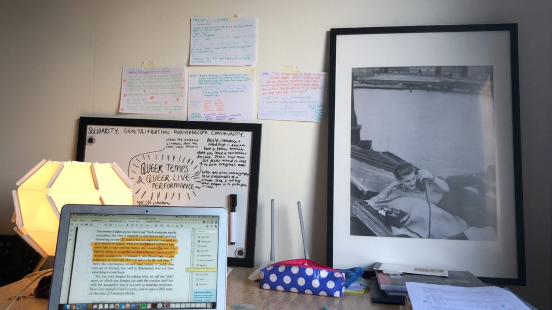 Emma's study station, featuring a laptop, notes, books and a lamp.