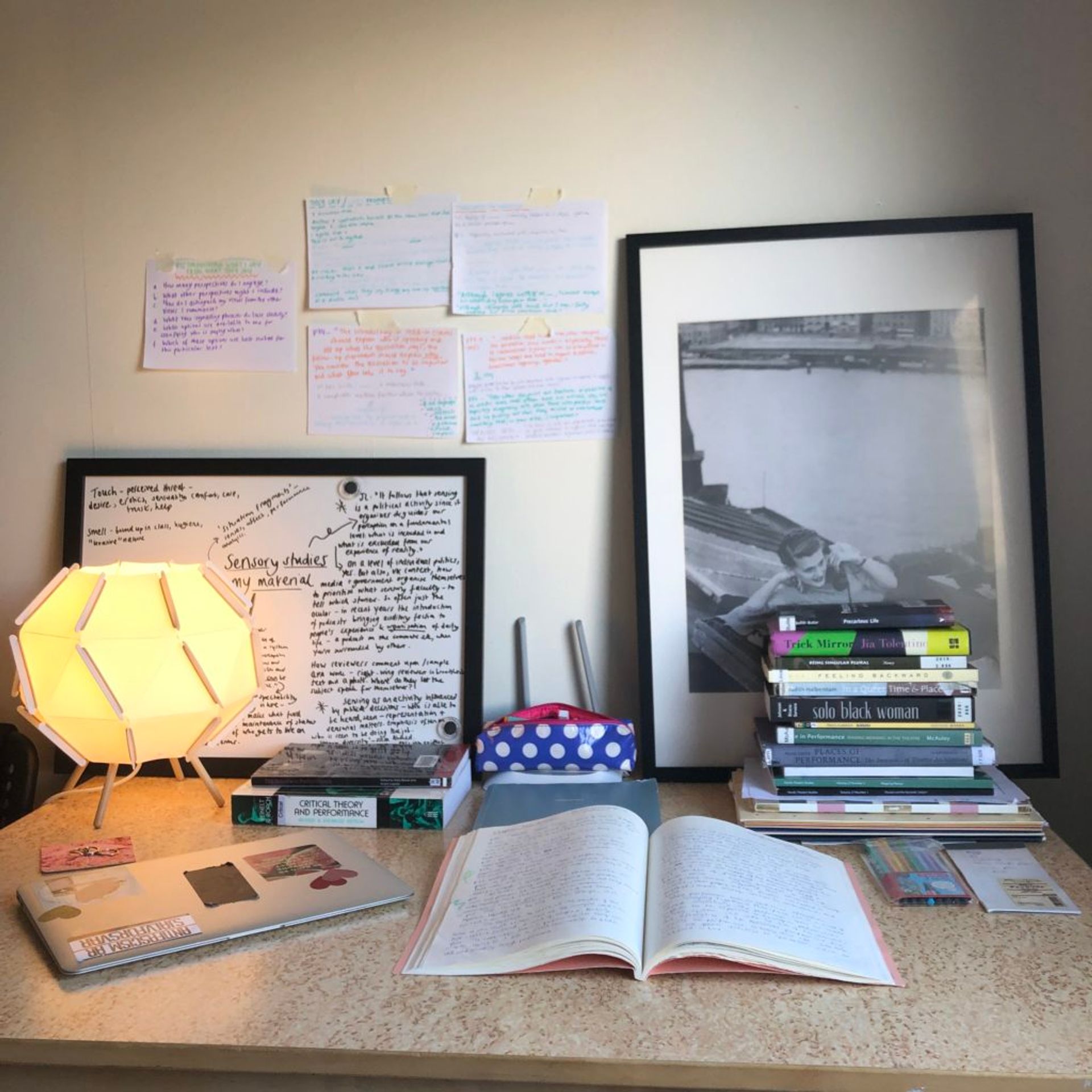 Stacks of books and an open book on a table.