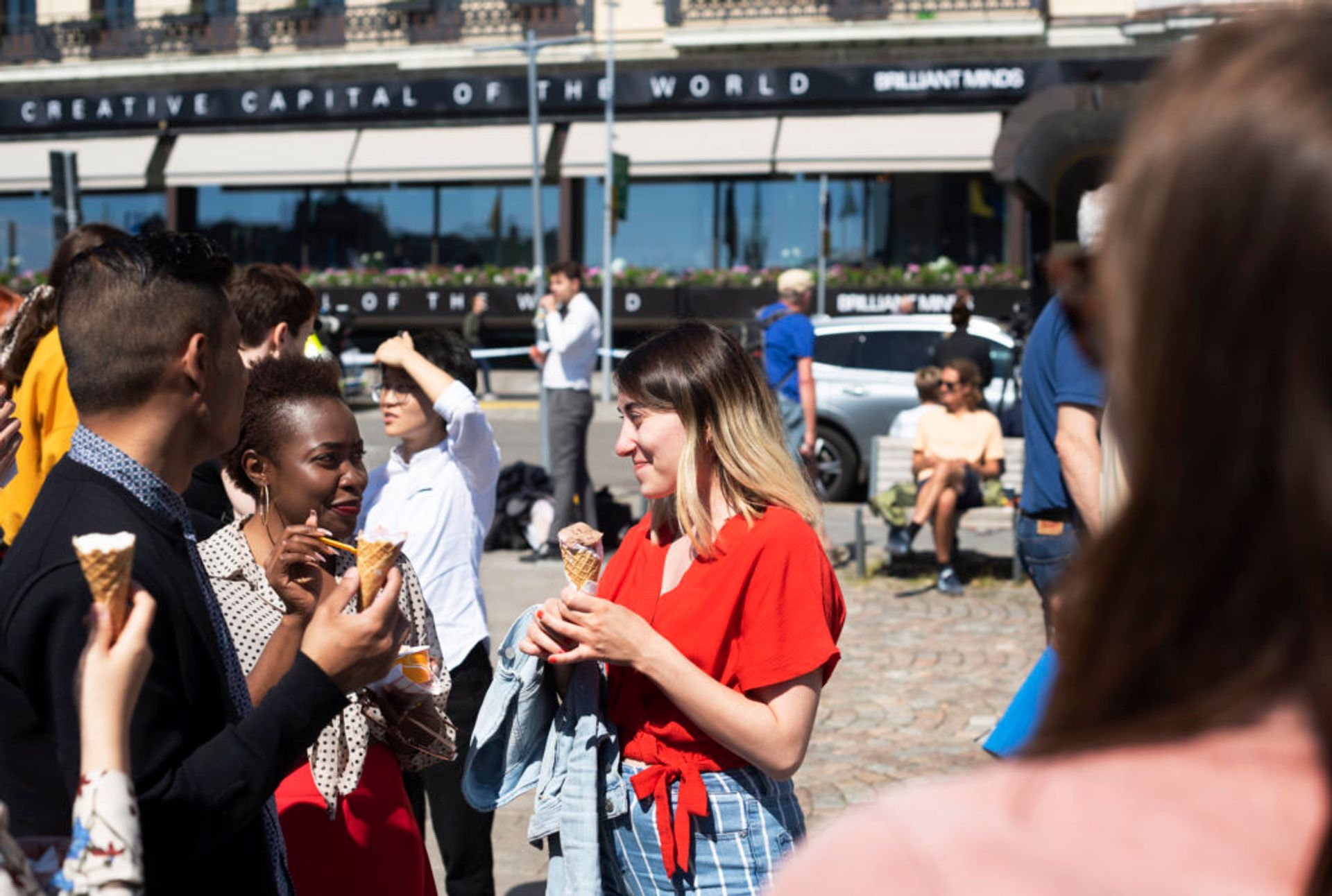 Hazal and two other students stand outside eating ice cream.