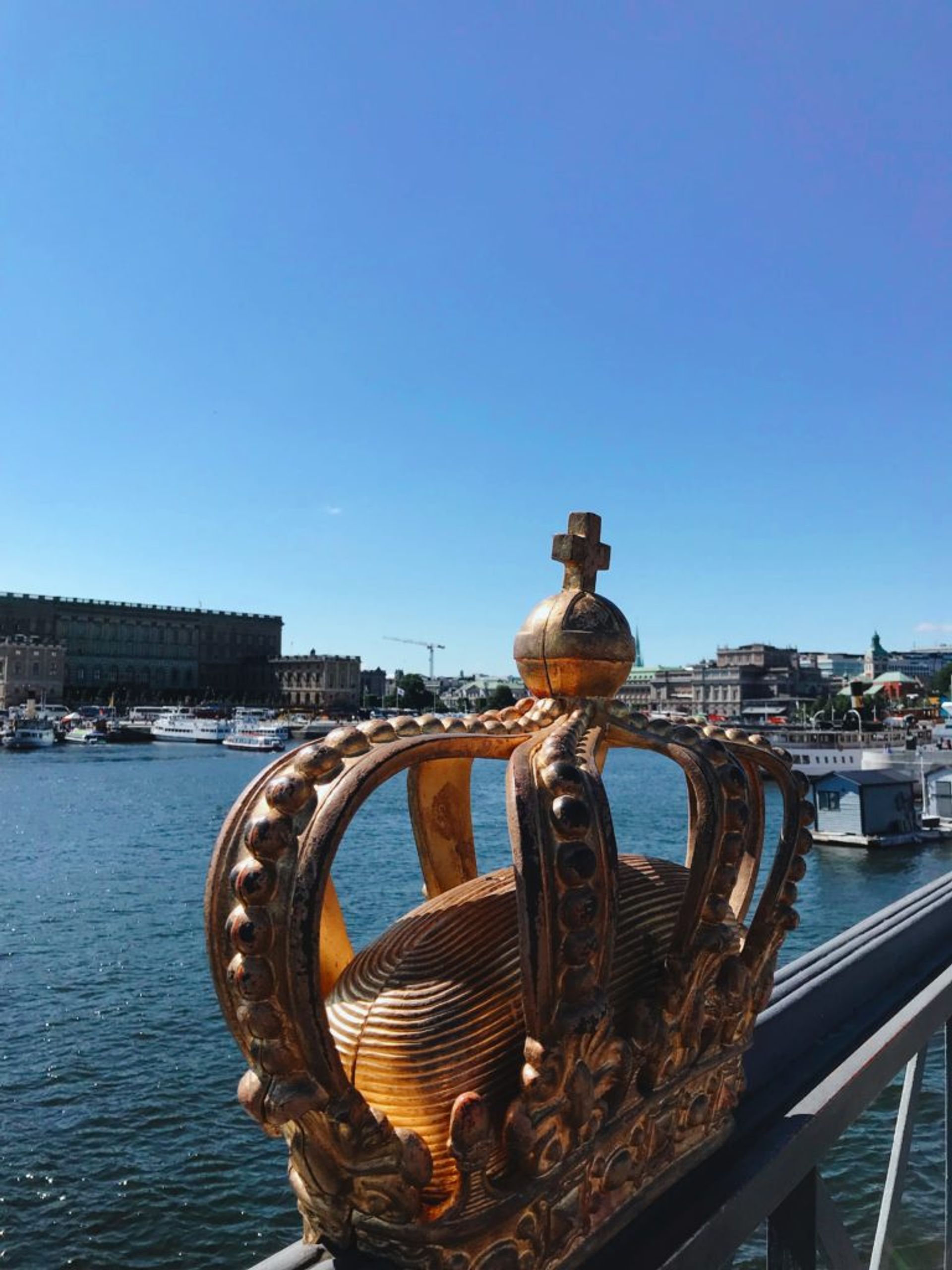 A gold coloured crown on a bridge in Stockholm.