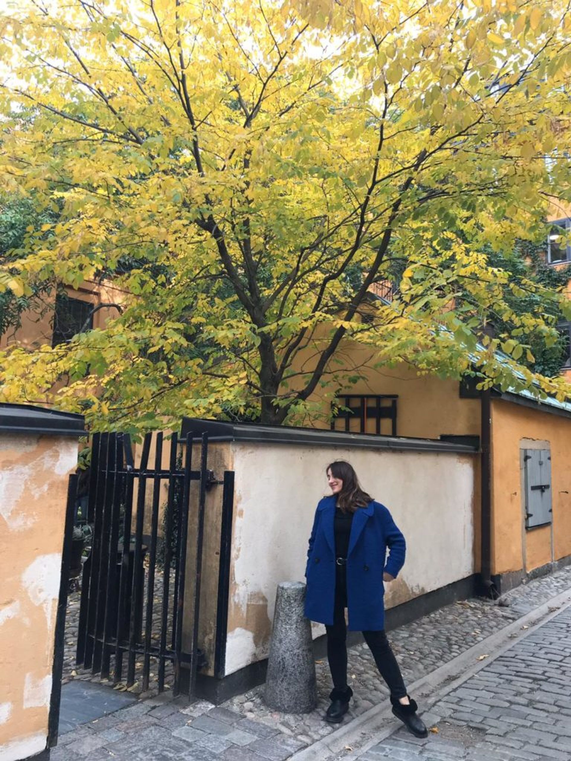 Hazal stands on a cobbled street in Stockholm's Old Town.