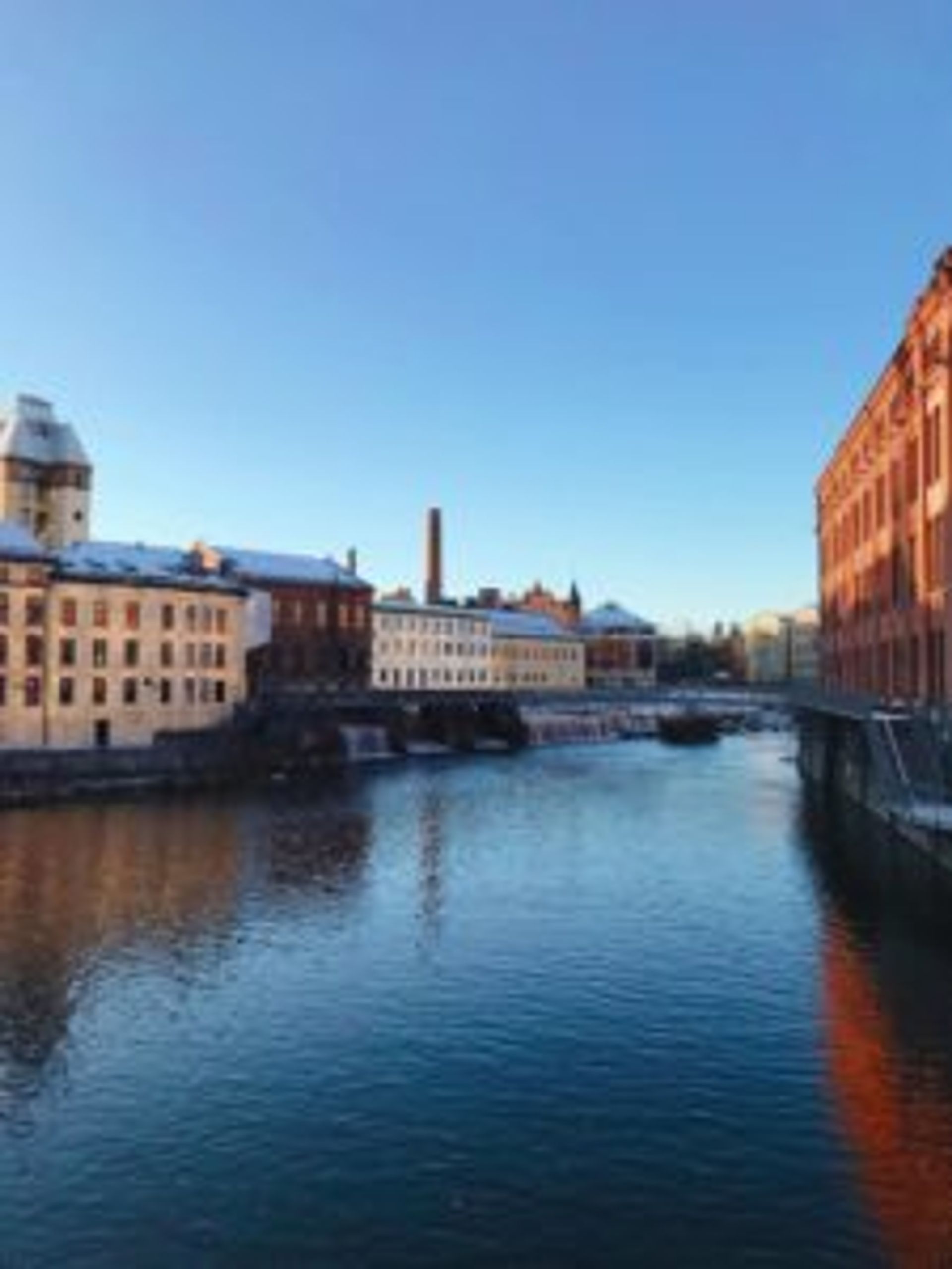 Red brick buildings beside the river.