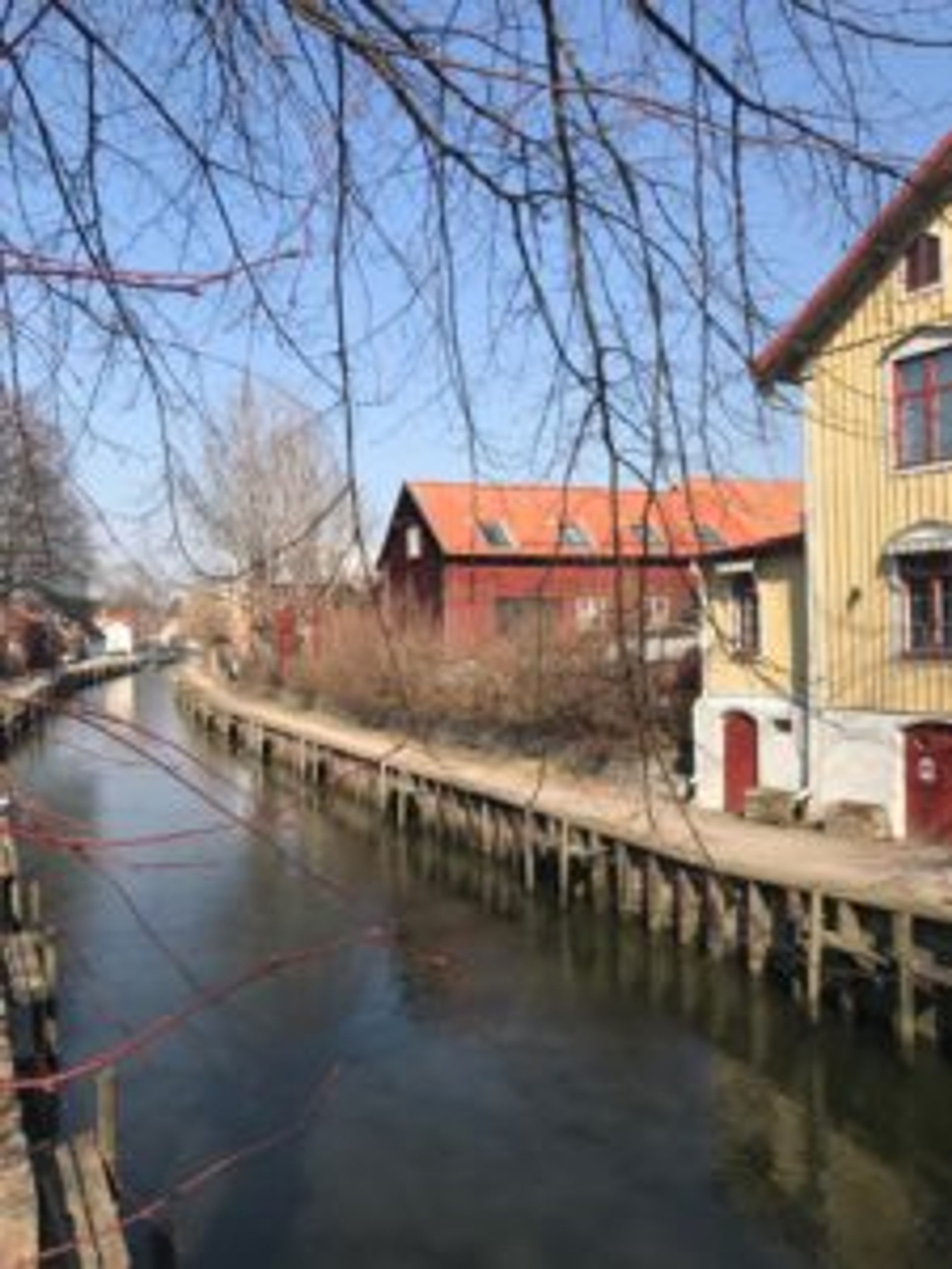 Old, wooden buildings by a river.