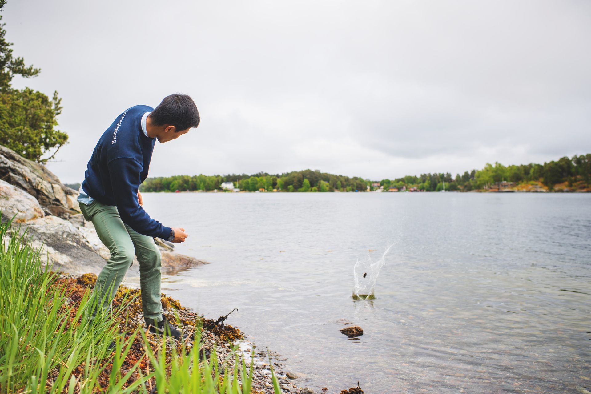 Man skimming stones on a lake.