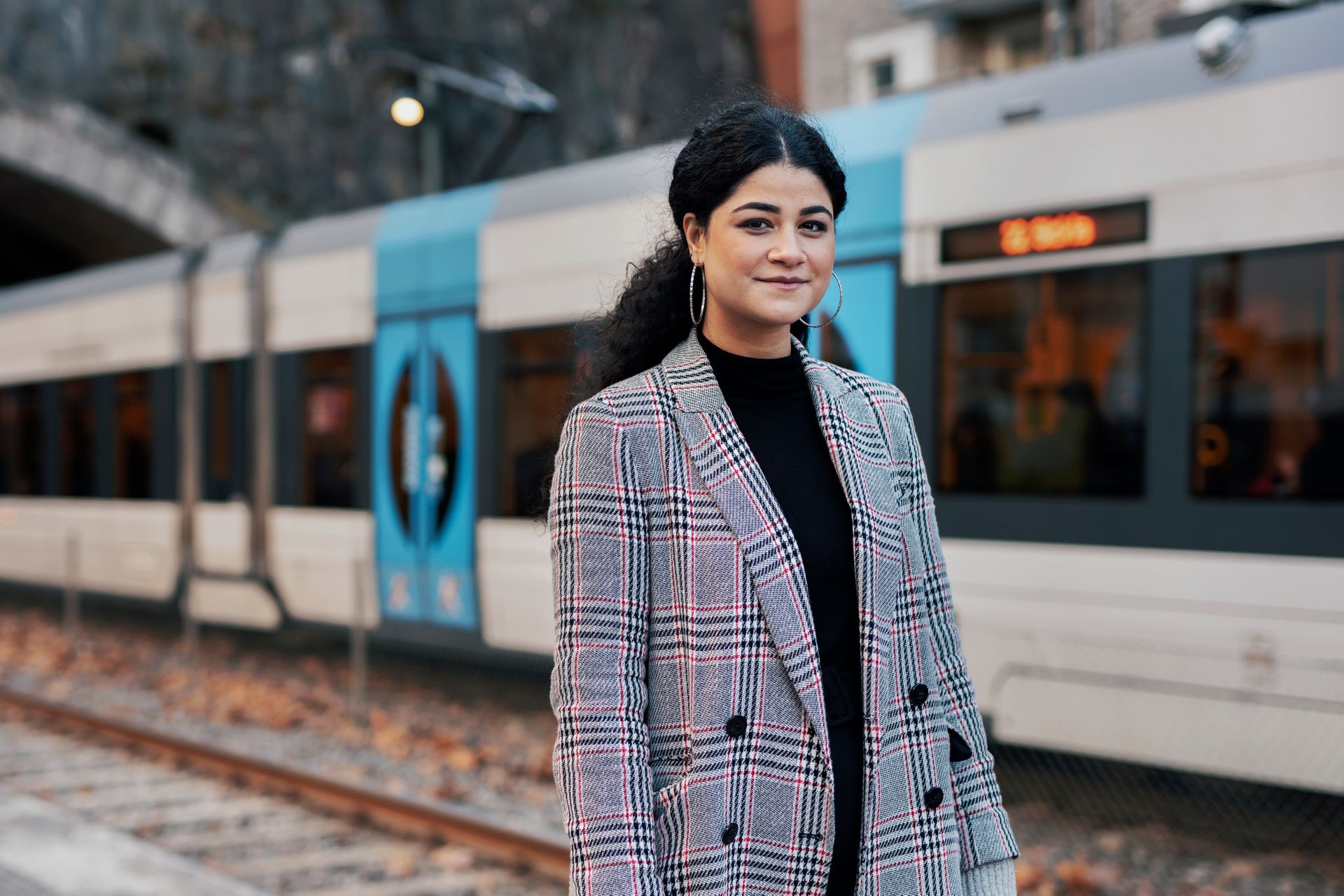 International student from Brazil standing in front of a tram in Sweden