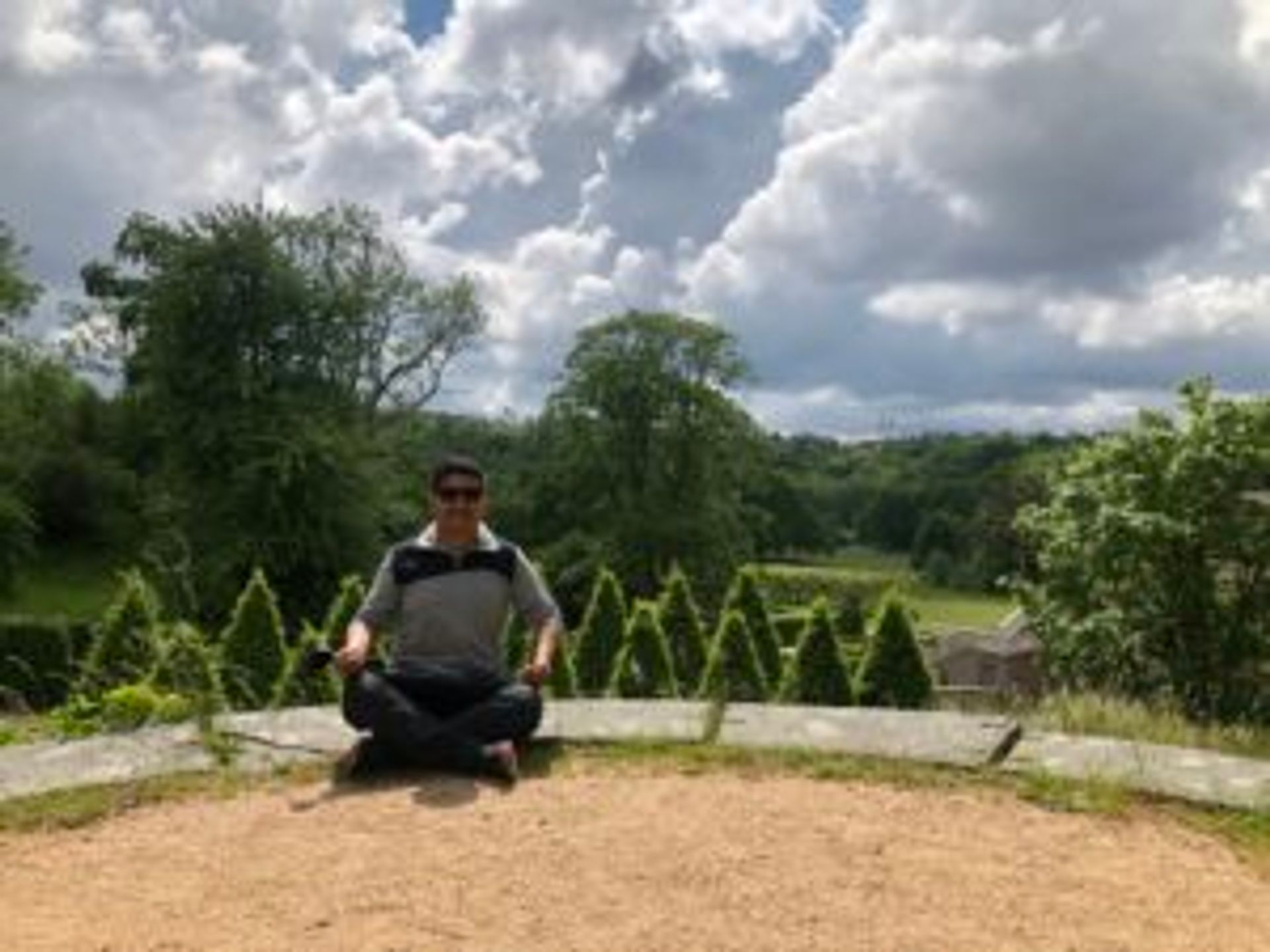 Camilo sits in the gardens at Gunnebo House.