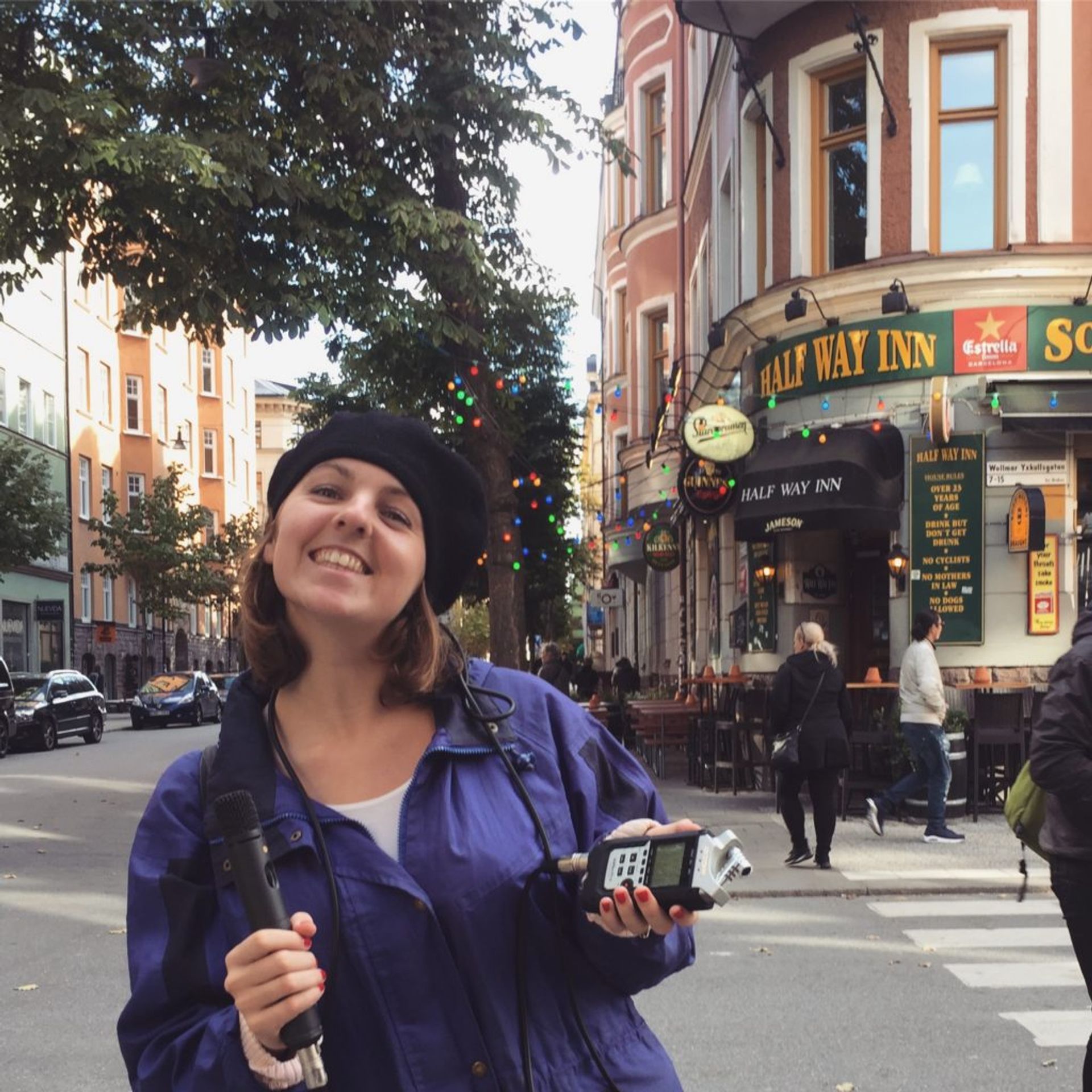 Emma holds a microphone in a street in Stockholm.