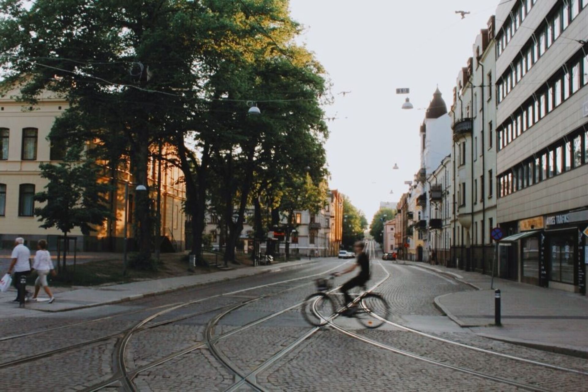 Person cycling across a cobbled street in Norrköping.