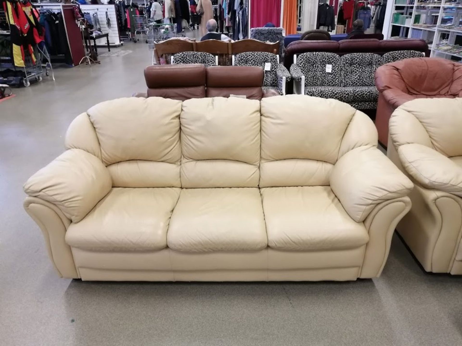 Rows of leather sofas for sale at second hand store.