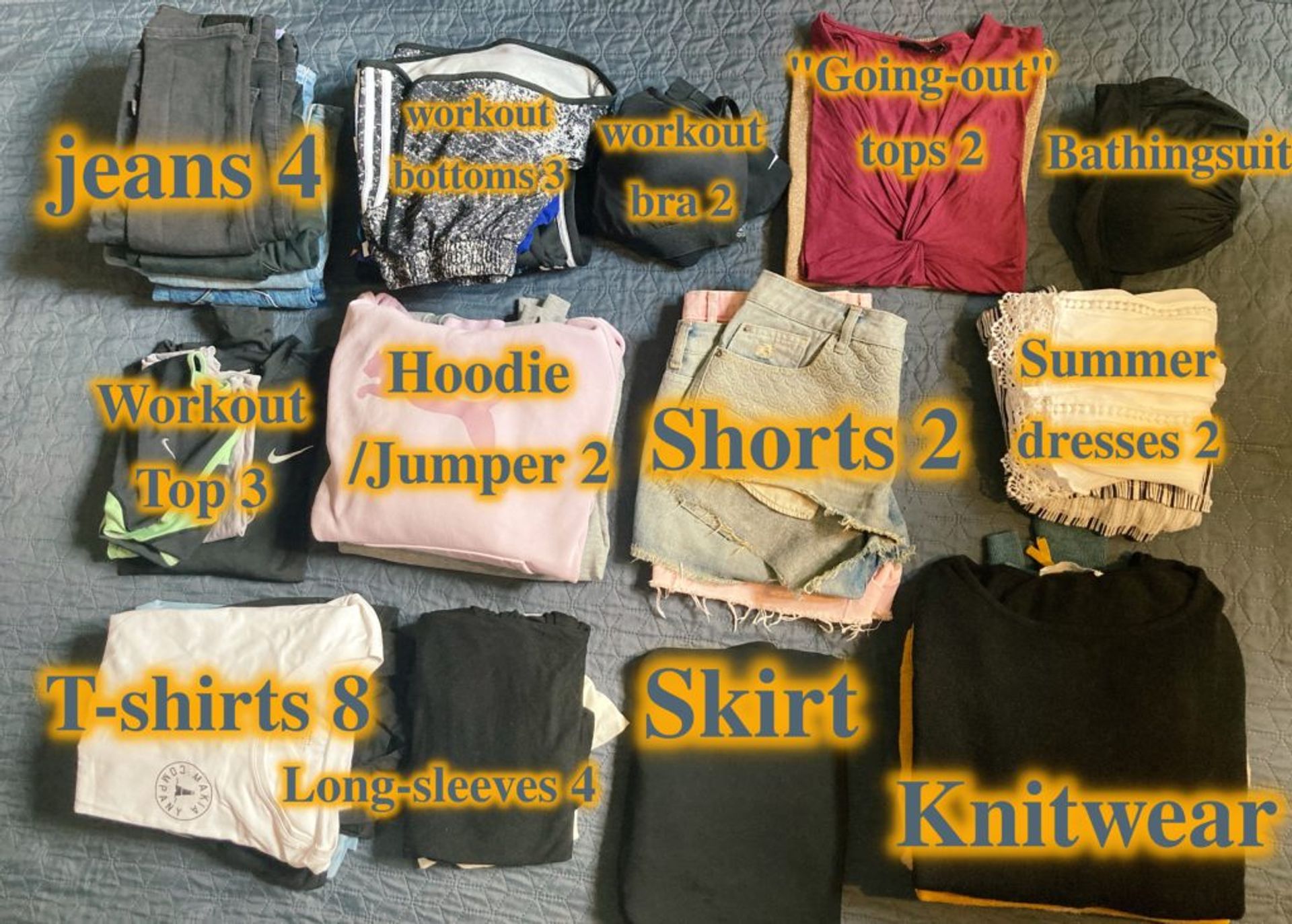 A mixture of different clothing including jeans, knitwear, dresses, shorts.