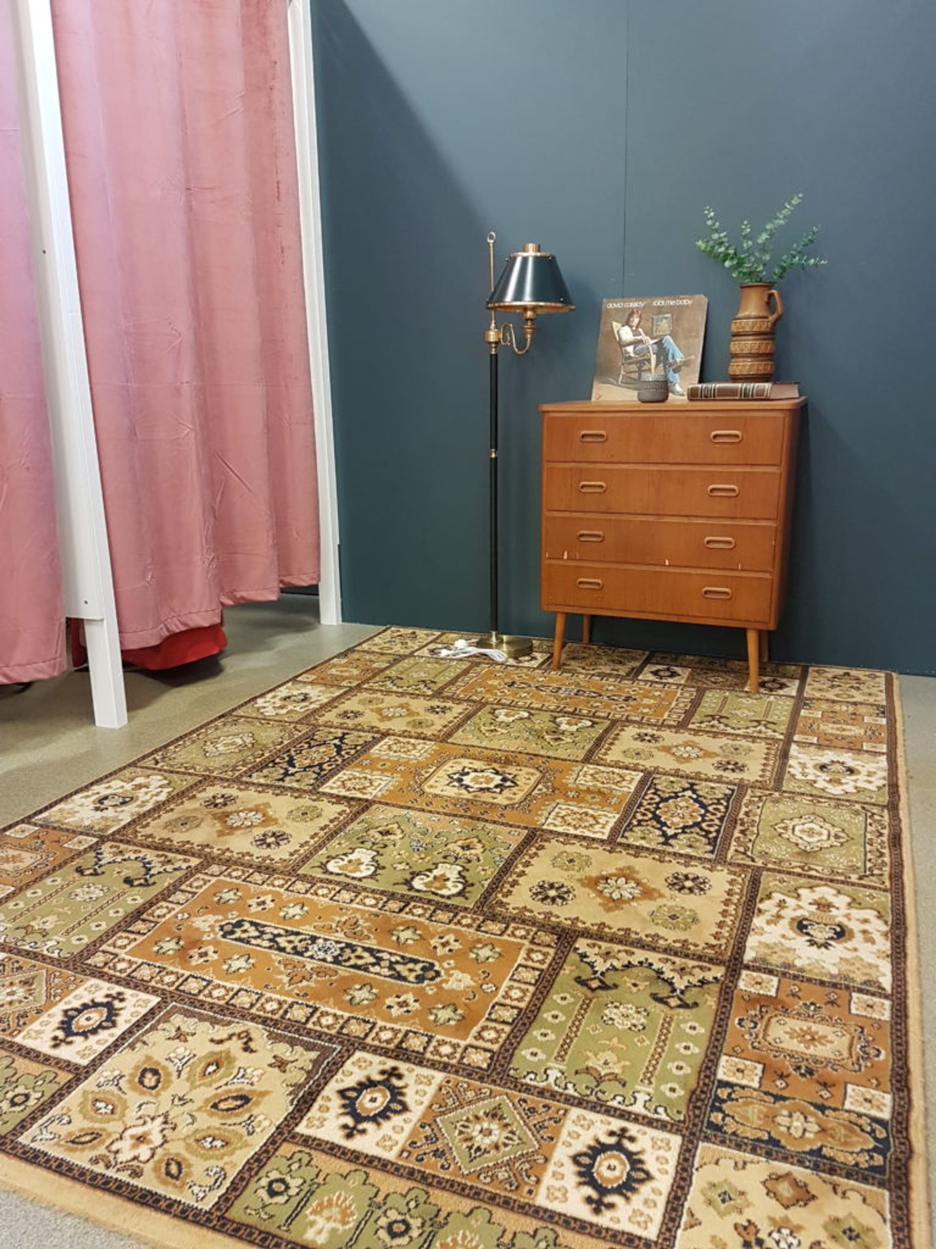 Teak sideboard and vintage rug outside of a store's changing rooms.