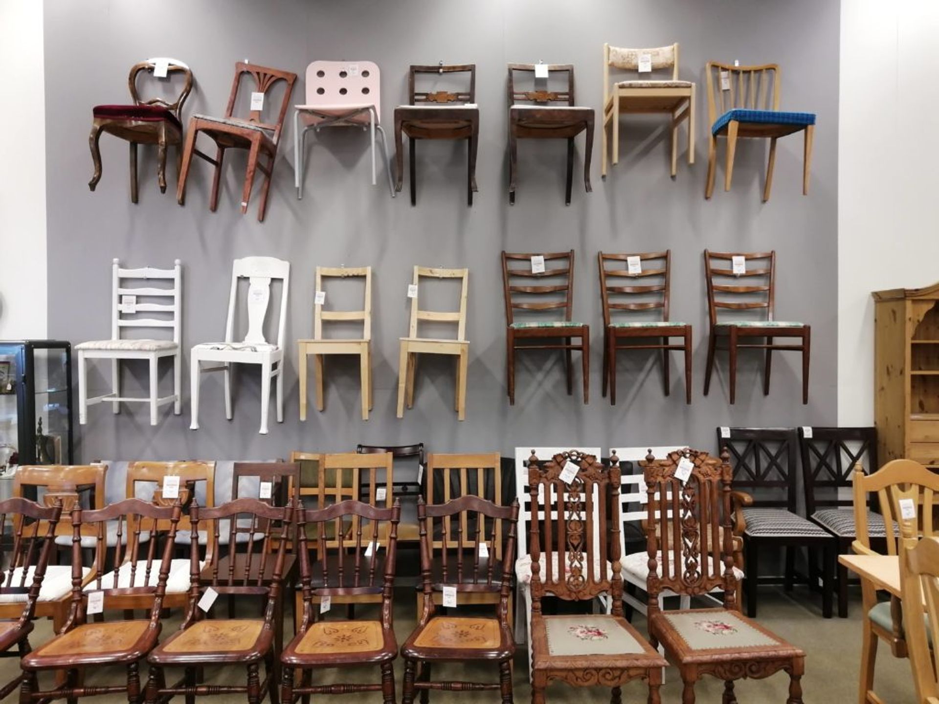 Rows of wooden chairs against a wall.