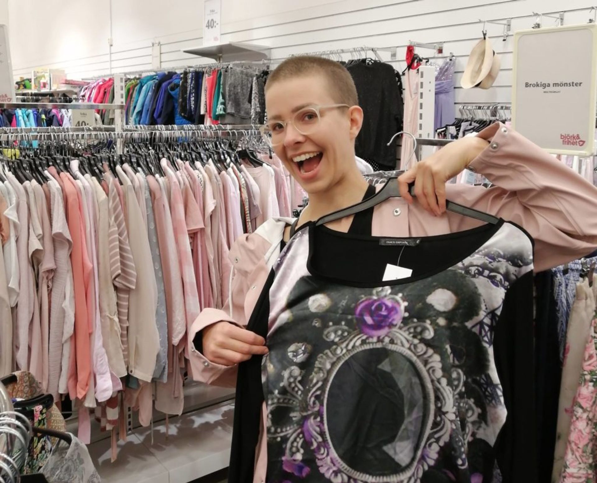 Lusanda's friend, Vera, holding up a top she found in the second hand shop Emmaus.