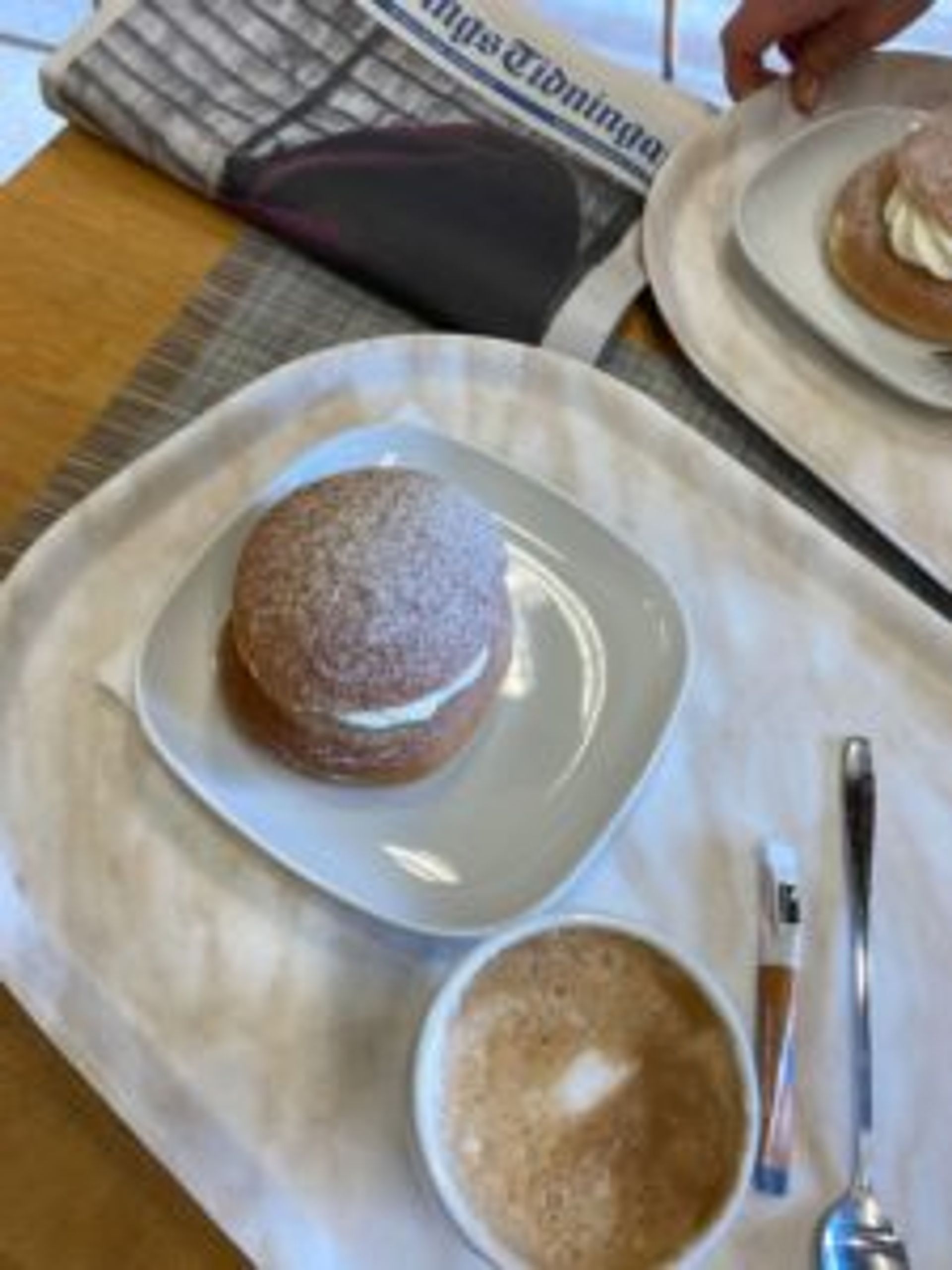 A tray with a cup of coffee and a semla - a traditional Swedish pastry.