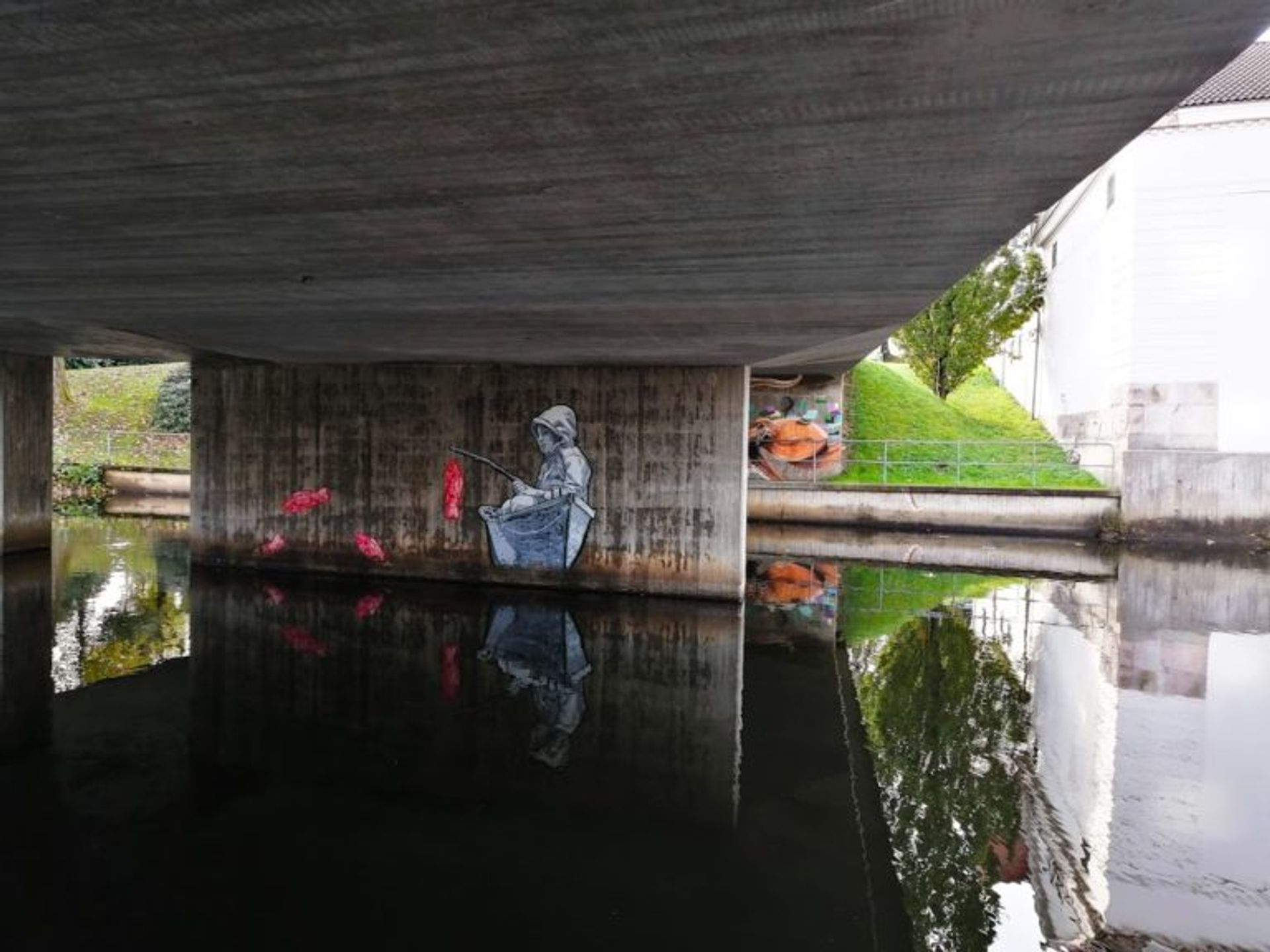 Mural of a child fishing in a boat painted on the side of a concrete pile of a bridge in Borås.