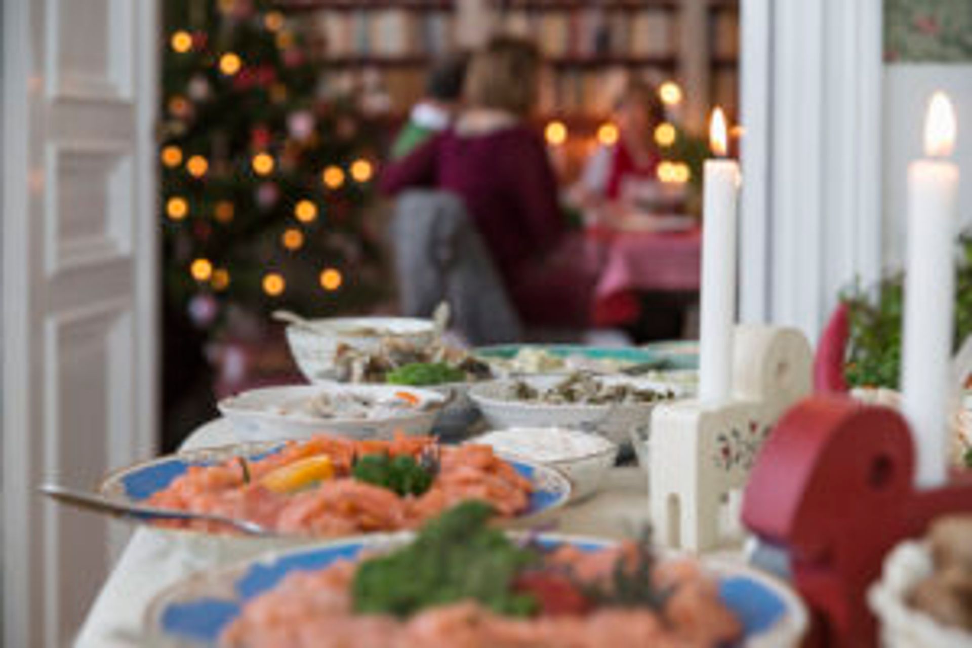 A Swedish Christmas smorgåsbord. A family eating Christmas dinner in the background.