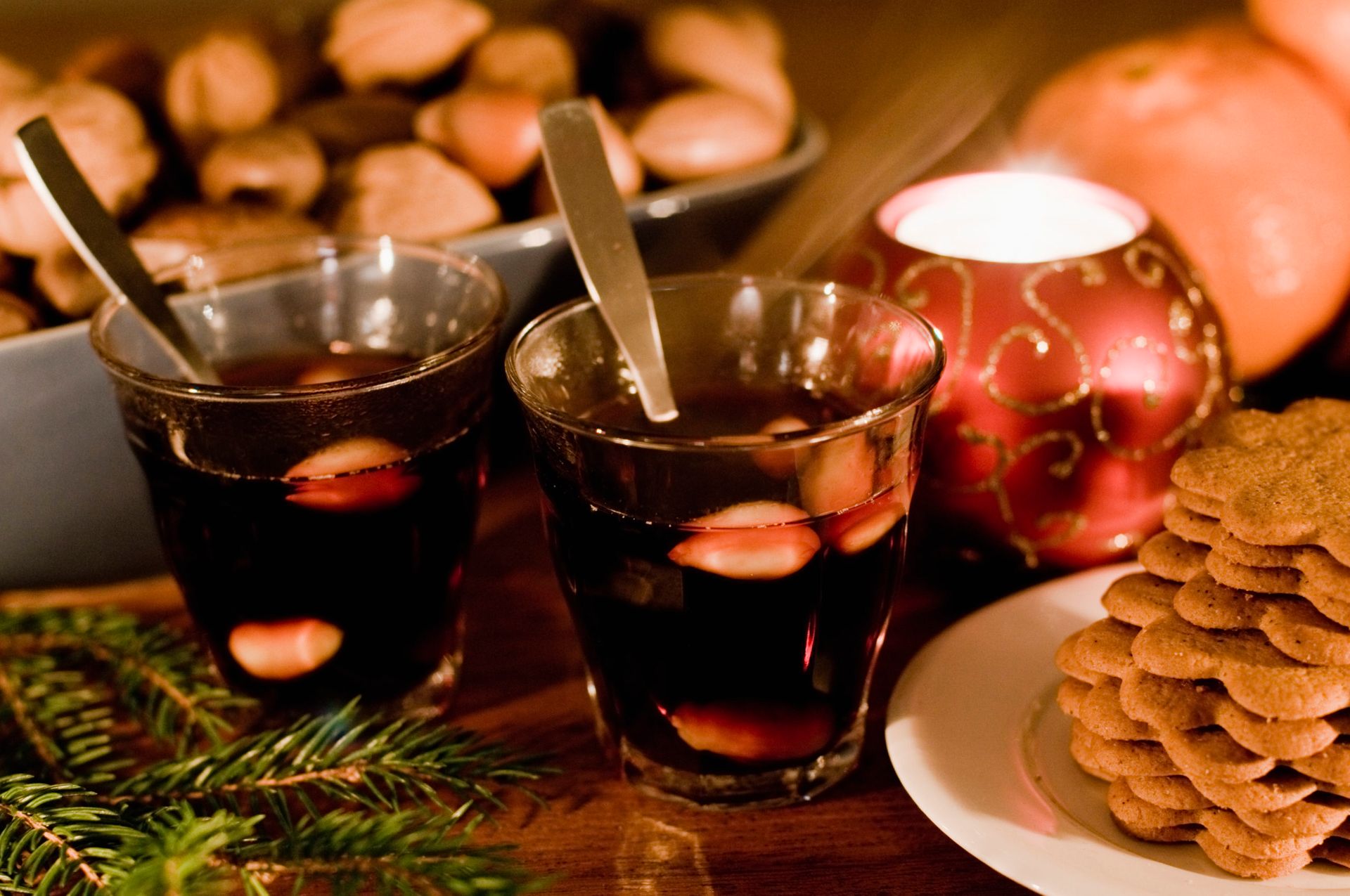 Two small glasses of Swedish mulled wine beside a plate of gingerbred cookies.