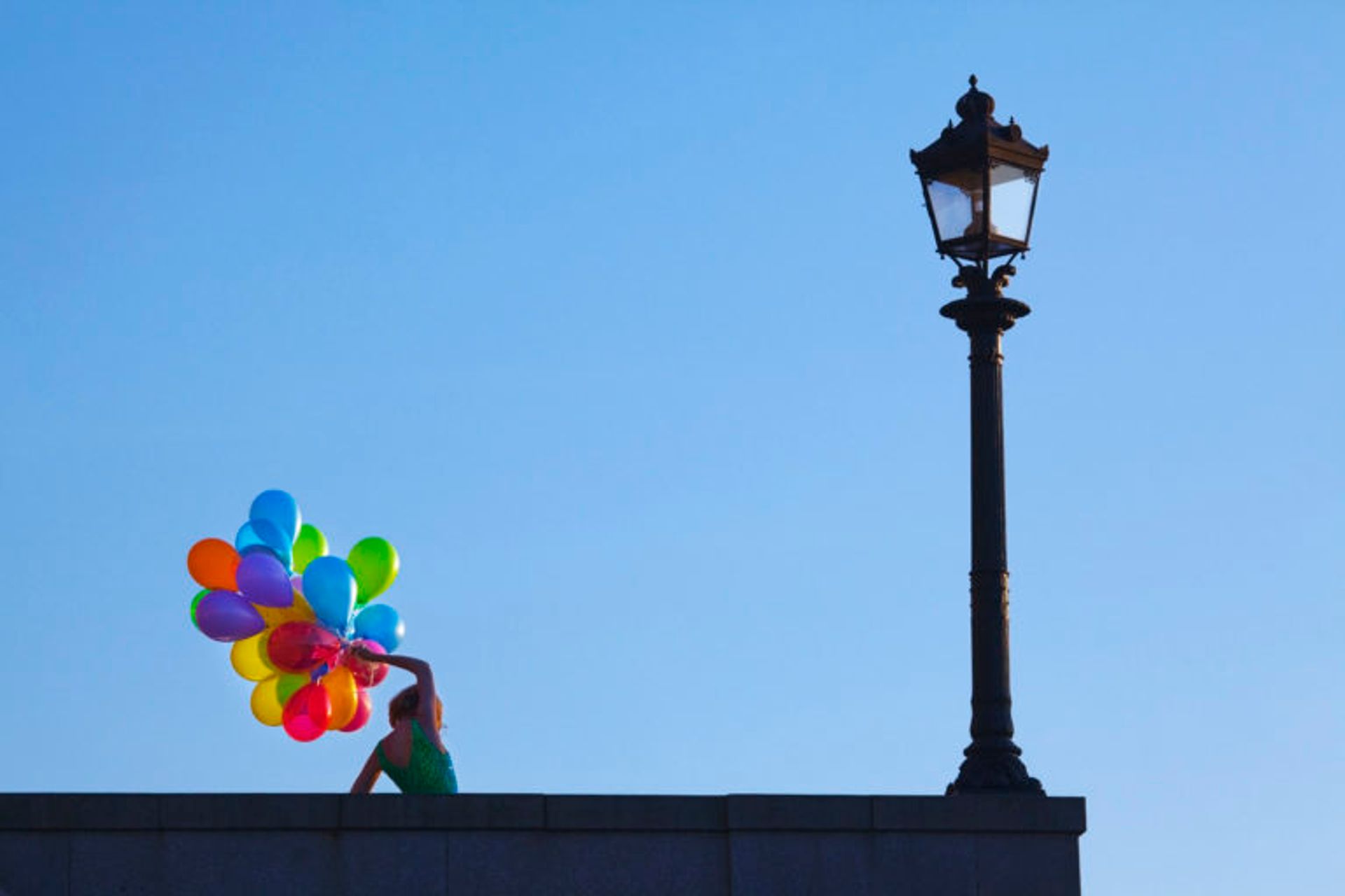 Person holds rainbow balloons