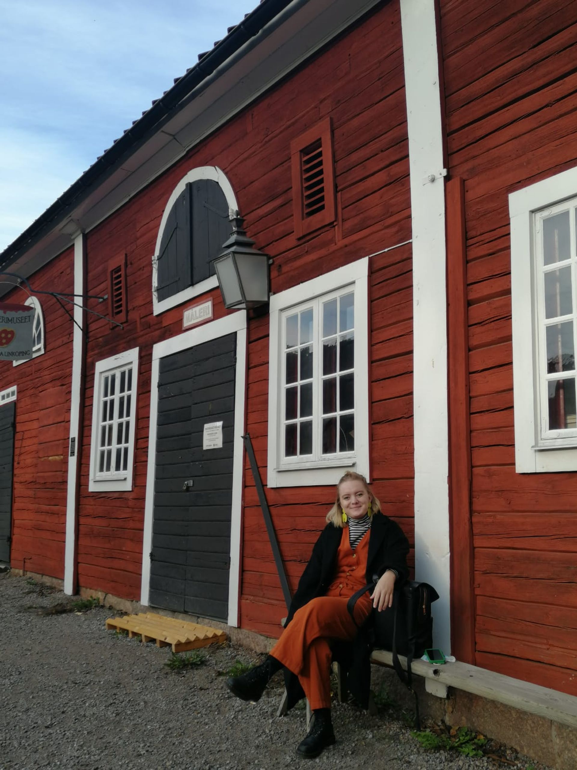 Brooke sitting in front of a red building