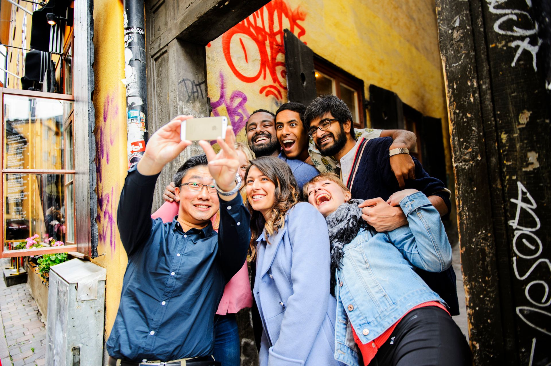 A group of international students taking a group selfie in Stockholm's Old Town.